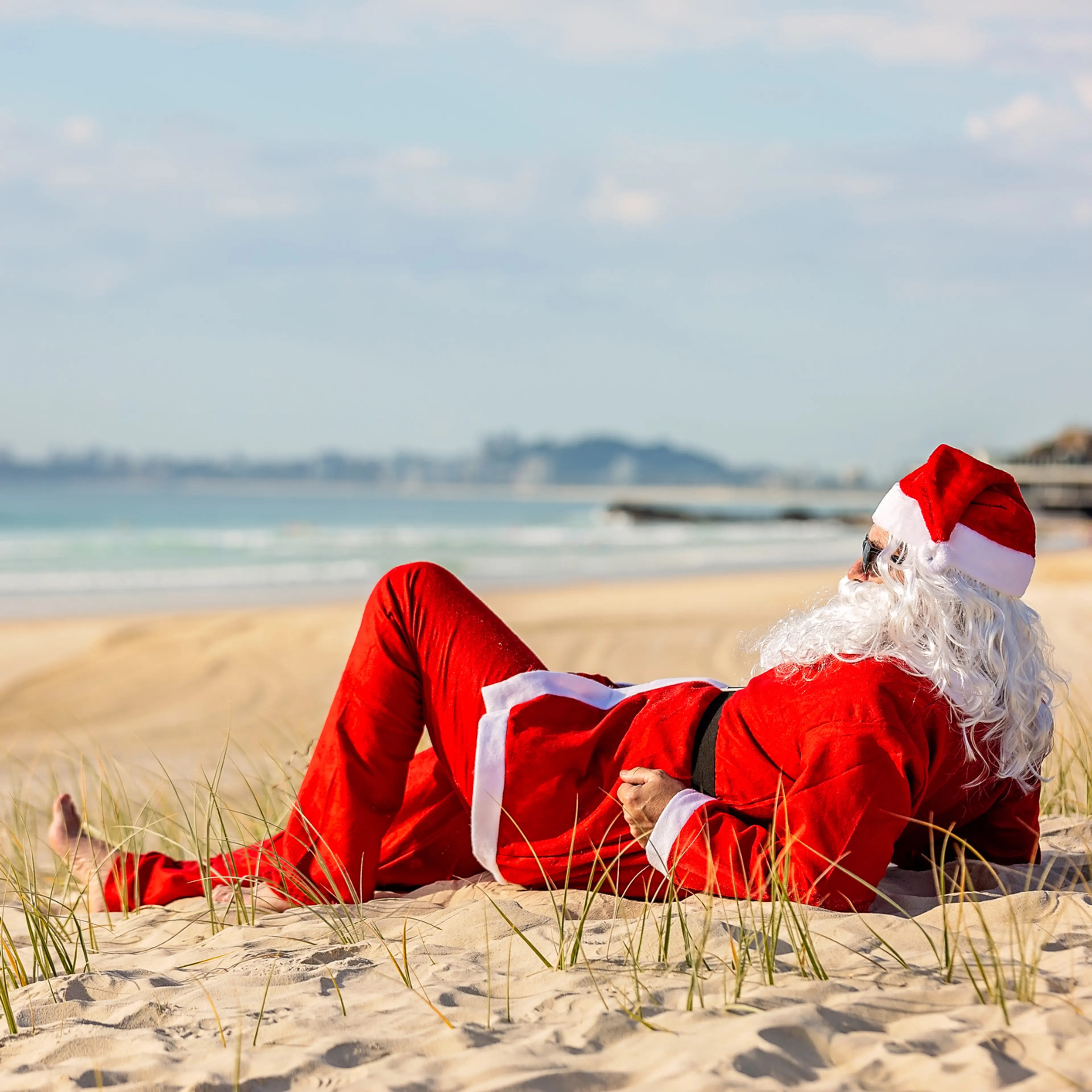 Summer Santa lying on the beach