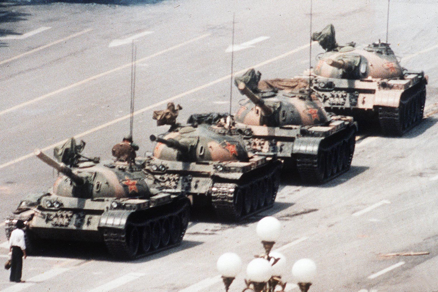 A Chinese man stands alone to block a line of tanks heading east on Beijing's Changan Avenue in Tiananmen Square on June 5, 1989. The man, calling for an end to the recent violence and bloodshed against pro-democracy demonstrators, was pulled away by bystanders, and the tanks continued on their way.
