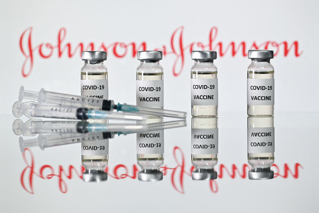 An illustration picture shows vials with COVID-19 vaccine stickers attached and syringes with the logo of U.S. pharmaceutical company Johnson &amp; Johnson on November 17, 2020.