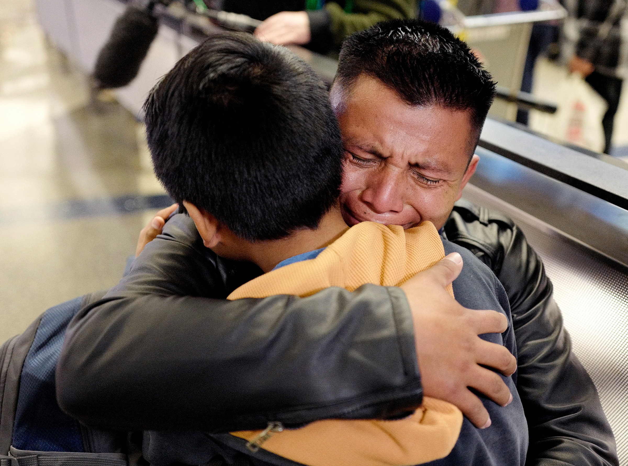 A father from Guatemala hugs his son in January 2020 at Los Angeles International Airport as they reunite after being separated about one and half years ago during the Trump administration's wide-scale separation of immigrant families