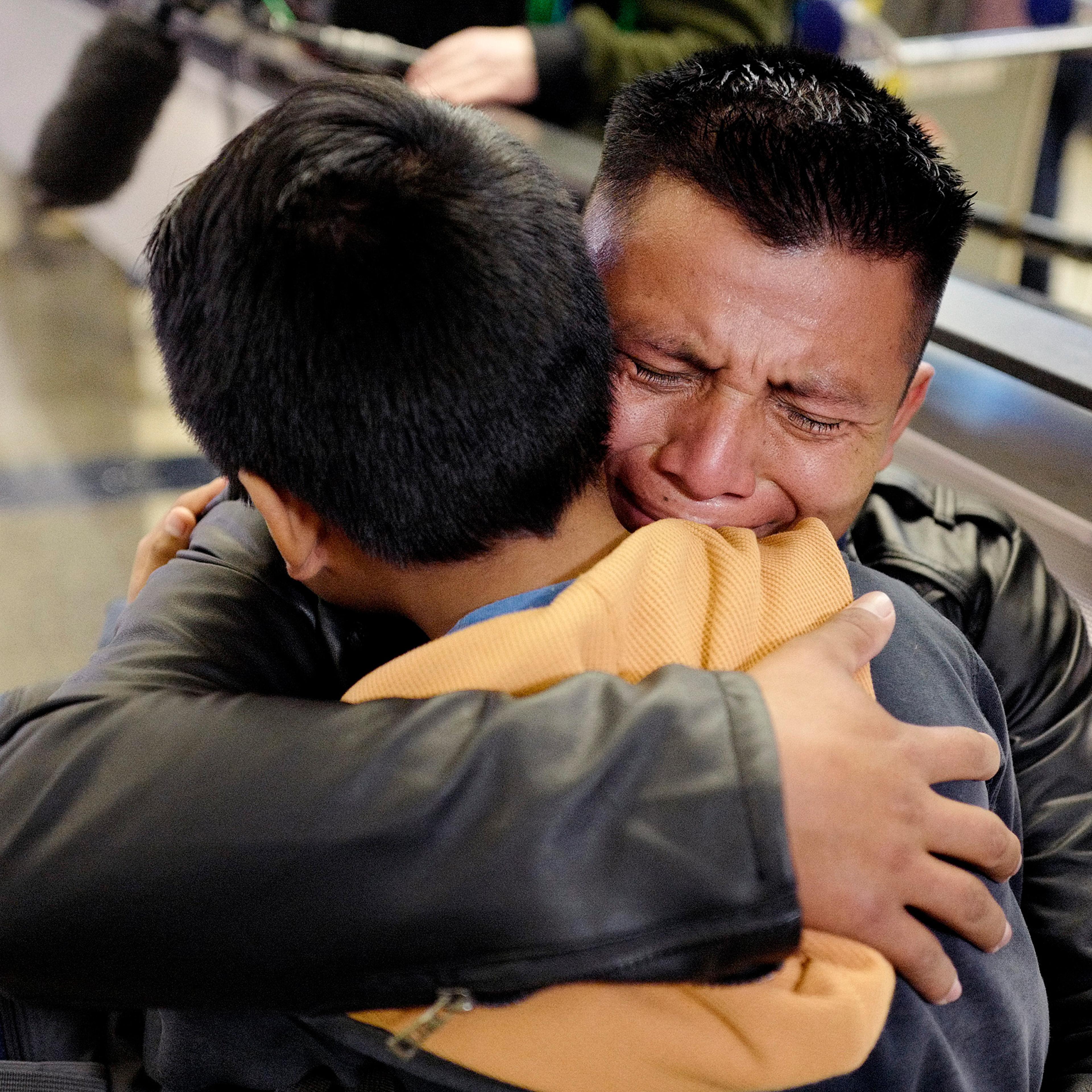 A father from Guatemala hugs his son in January 2020 at Los Angeles International Airport as they reunite after being separated about one and half years ago during the Trump administration's wide-scale separation of immigrant families