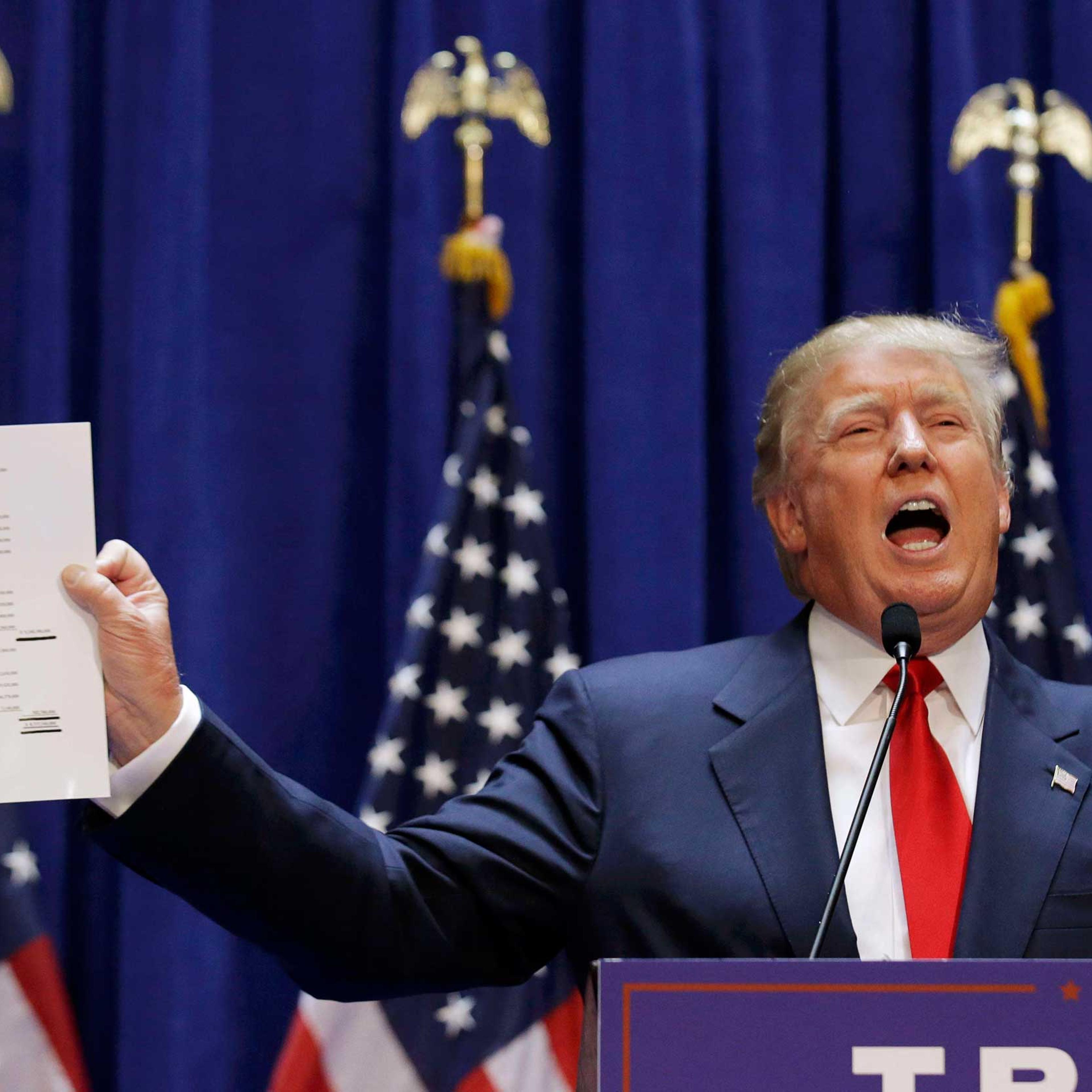 U.S. Republican presidential candidate Trump holds up his financial statement as he formally announces his campaign for the 2016 Republican presidential nomination at Trump Tower in New York