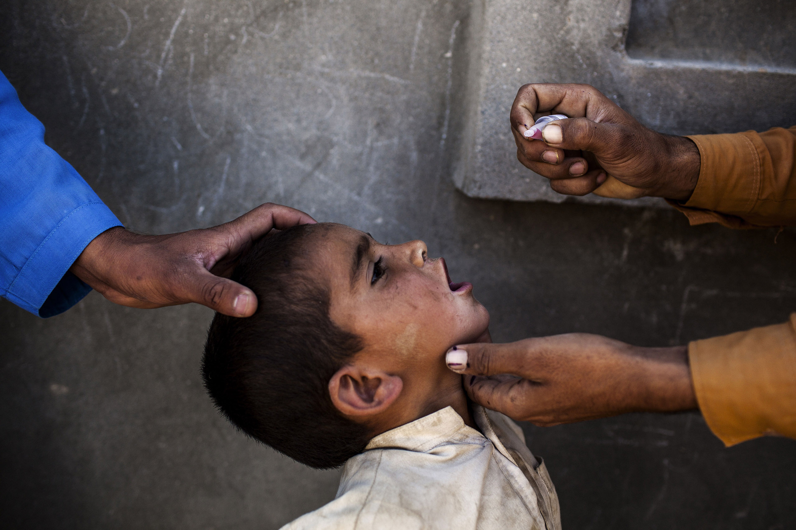 Health workers vaccinate a child for polio, a highly contagious virus, during the National Immunization Days in Jalalabad, Afghanistan.
