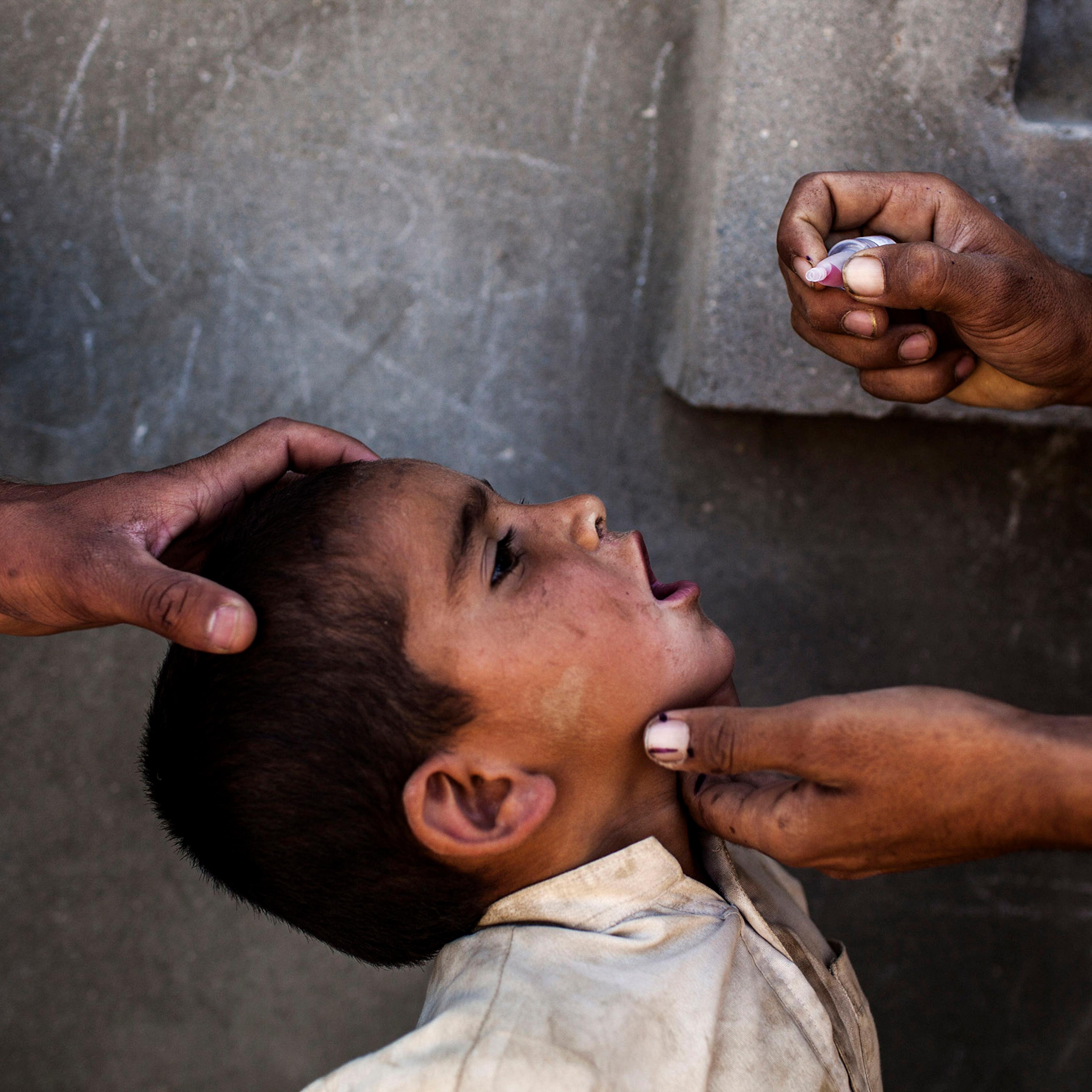 Health workers vaccinate a child for polio, a highly contagious virus, during the National Immunization Days in Jalalabad, Afghanistan.