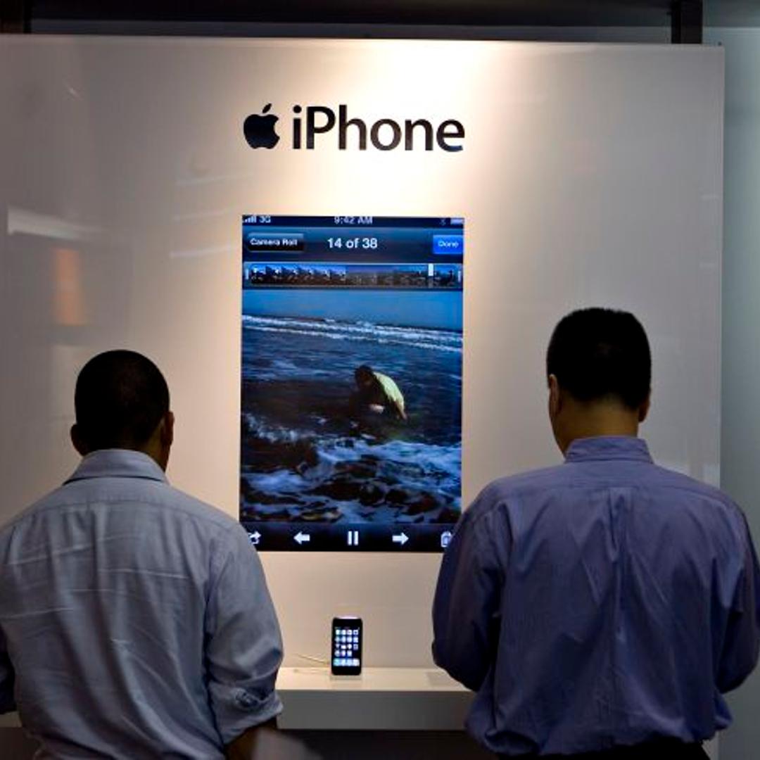Customers look over iPhone 3GS handsets inside an AT&T store