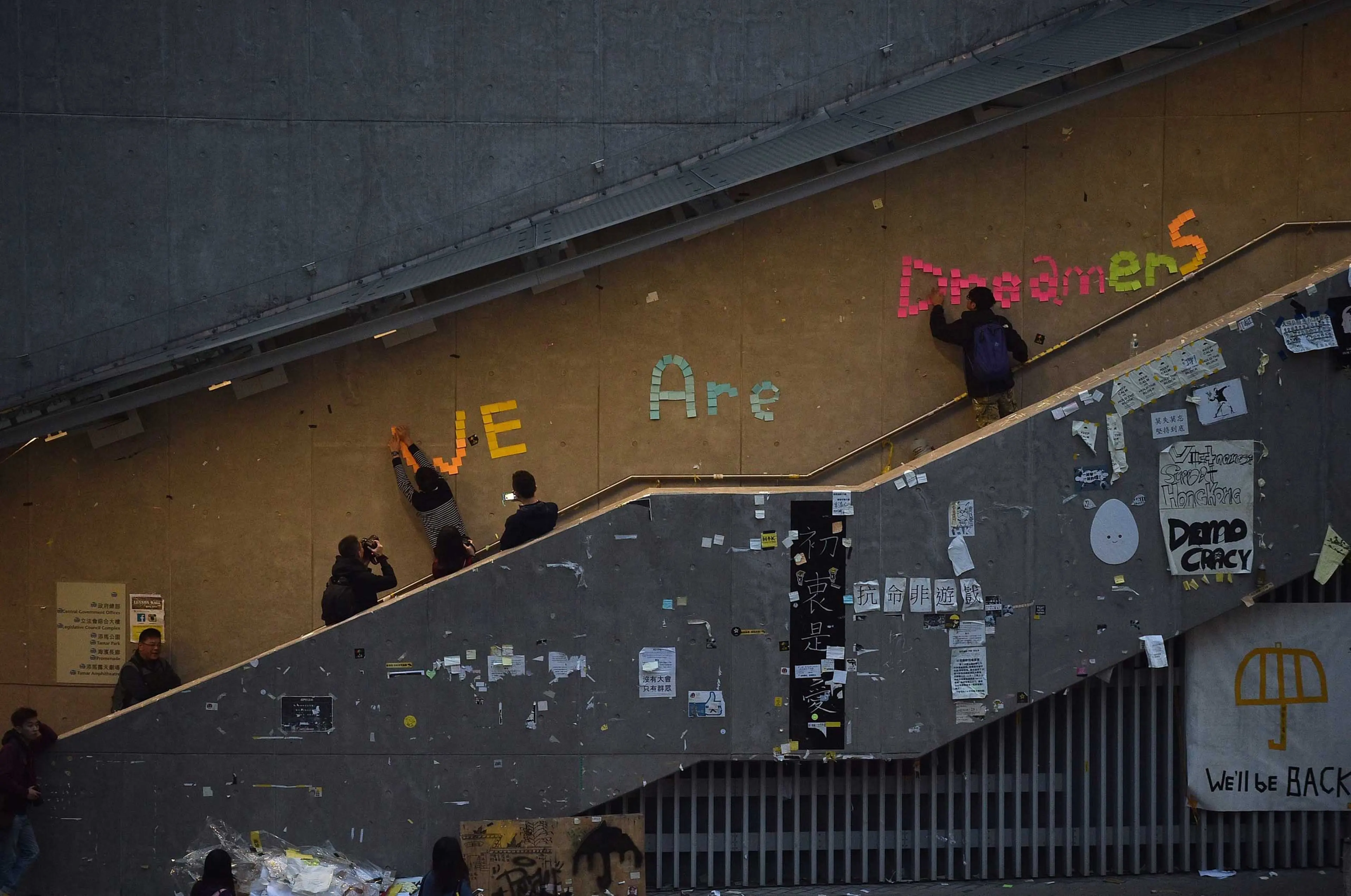 Pro-democracy protesters remove signs placed up during the past two months of protests from the area around the protest camp but leave intact the notice "We are dreamers" in the Admiralty in Hong Kong on Dec. 11, 2014.