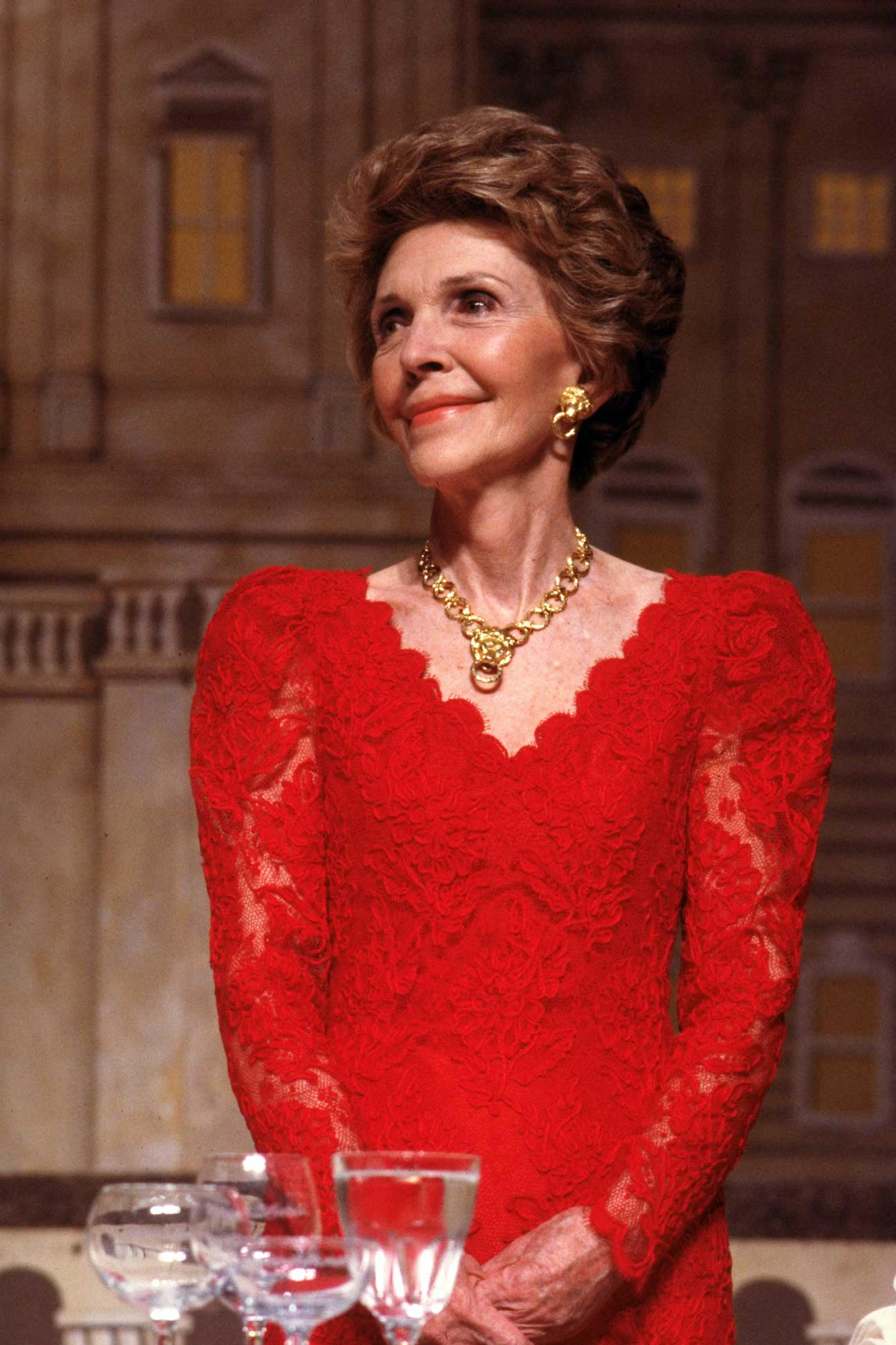 Nancy Reagan, decked out in red lace dress & gold