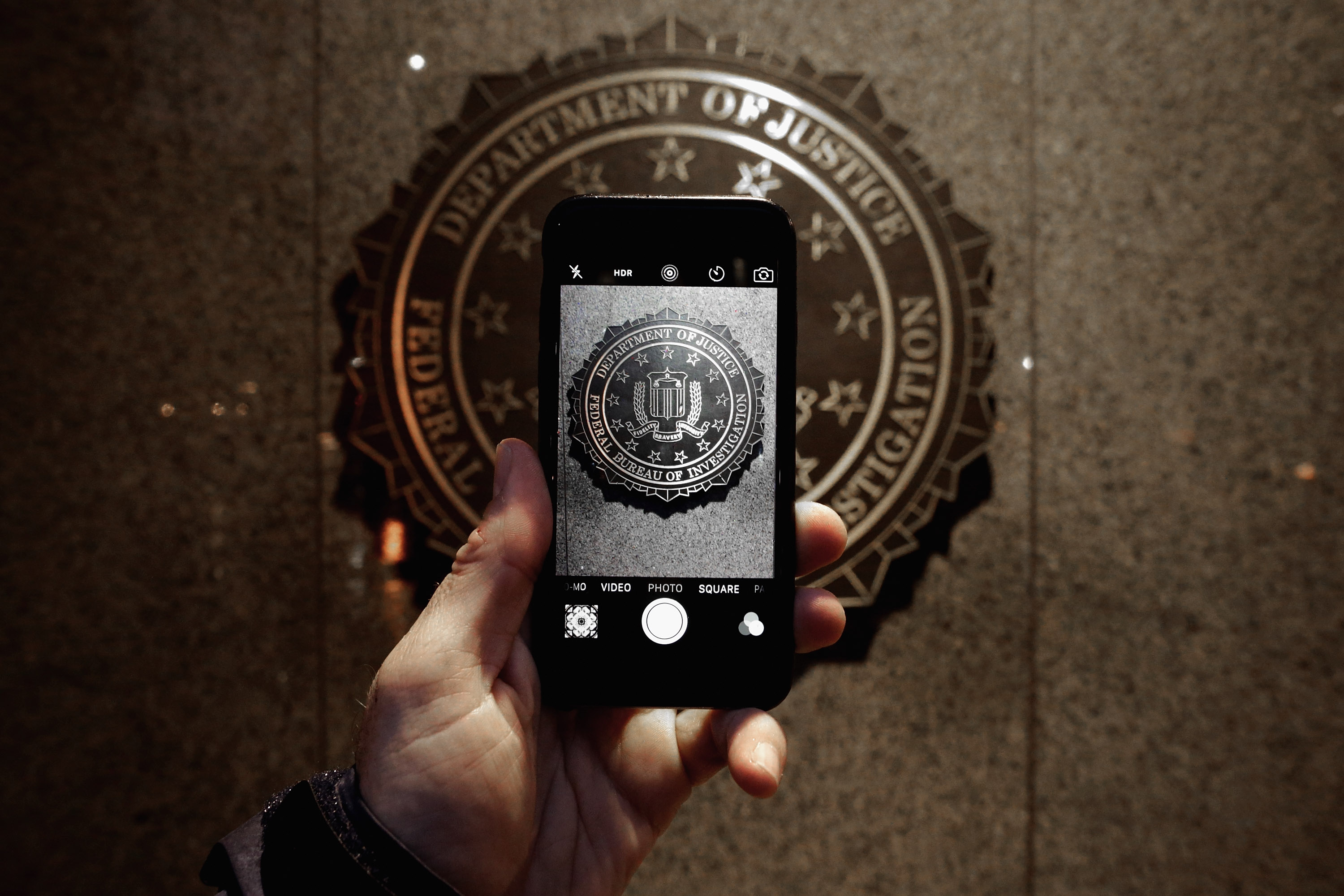 The official seal of the Federal Bureau of Investigation is seen on an iPhone's camera screen outside the J. Edgar Hoover headquarters February 23, 2016 in Washington, DC.