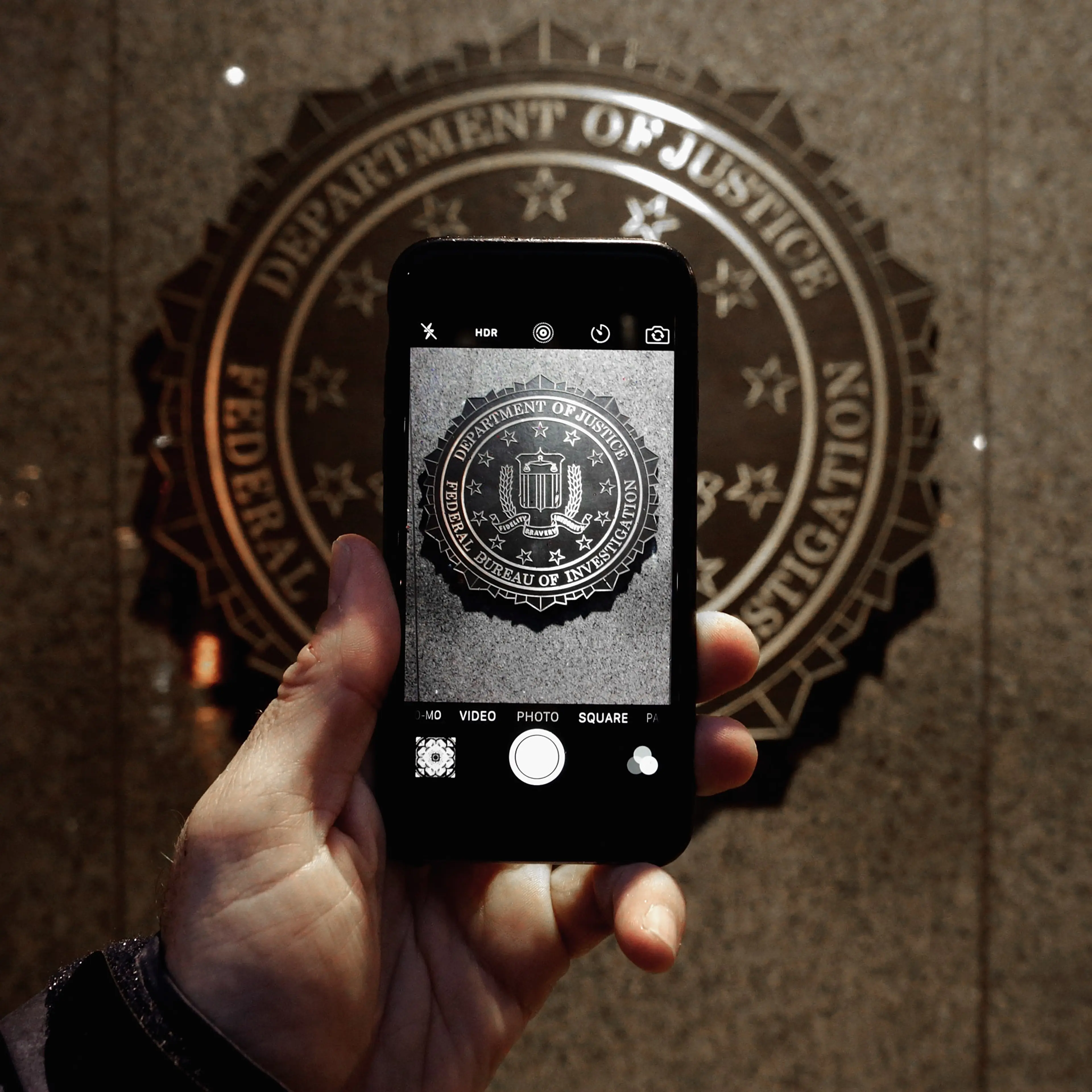 The official seal of the Federal Bureau of Investigation is seen on an iPhone's camera screen outside the J. Edgar Hoover headquarters February 23, 2016 in Washington, DC.