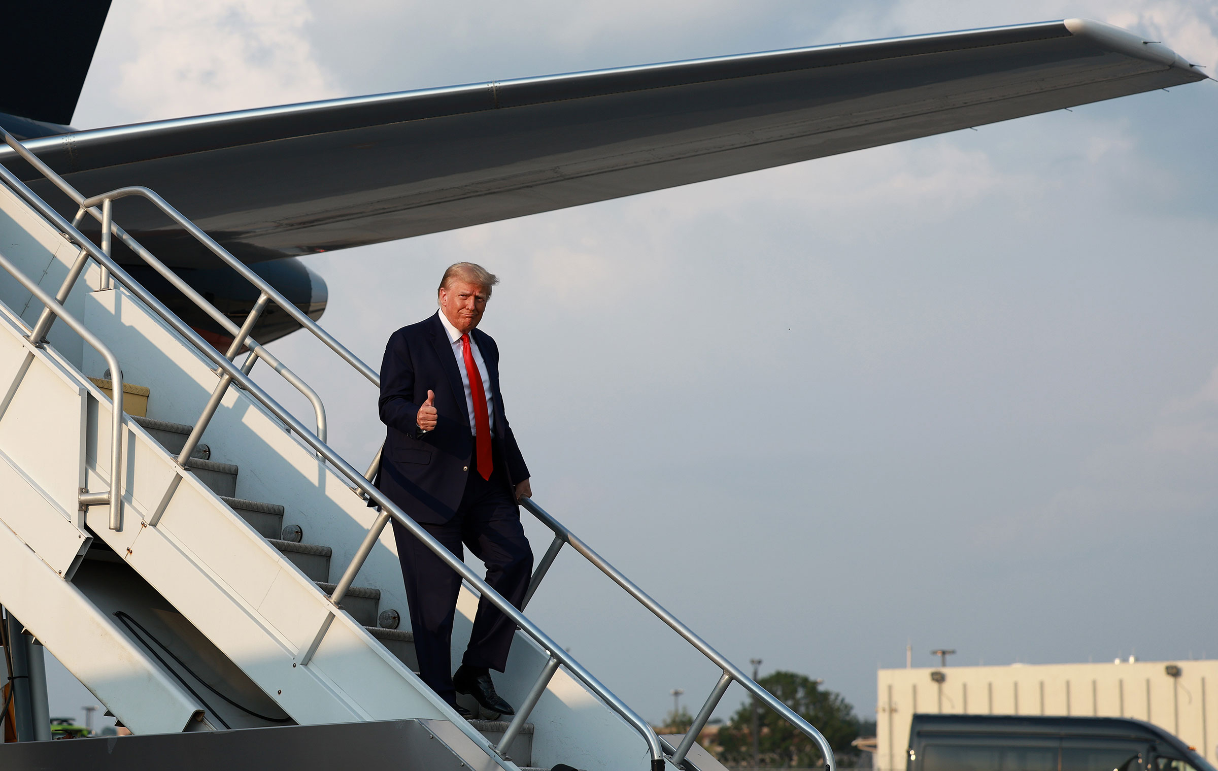 Former President Donald Trump gives a thumbs up as he arrives at Atlanta Hartsfield-Jackson International Airport on in Atlanta, Aug. 24, 2023.