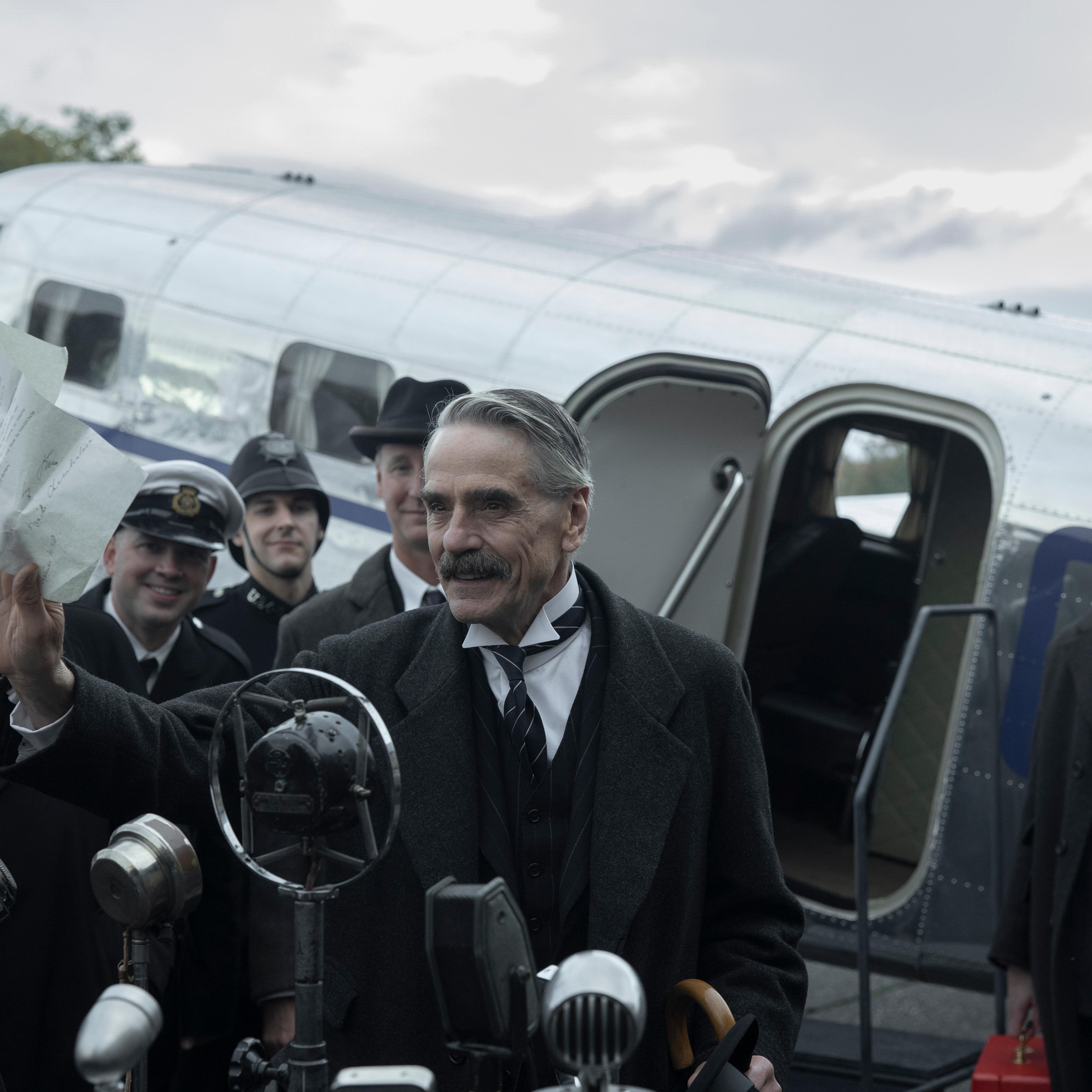 Munich - The Edge of War. (L to R) Jeremy Irons as Neville Chamberlain, George MacKay as Hugh Legat, in Munich - The Edge of War. Cr. Courtesy of Netflix © 2021