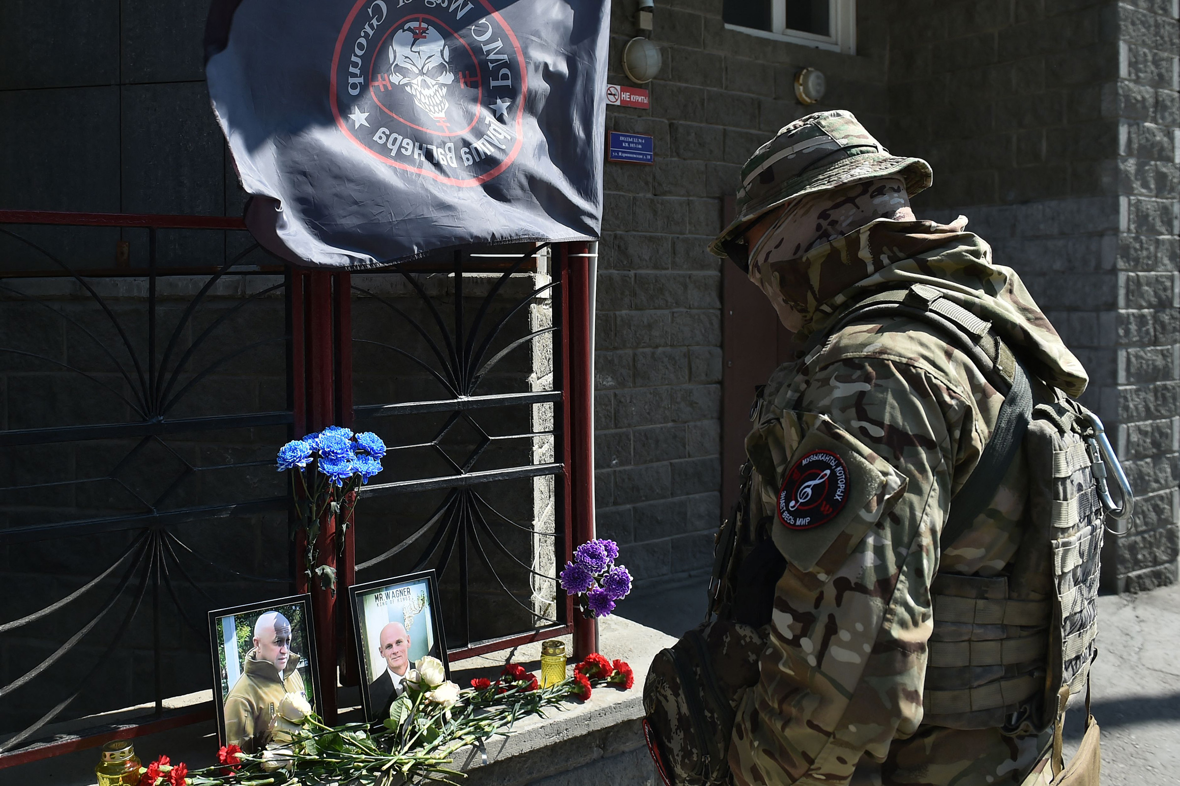 A member of private mercenary group Wagner pays tribute to Yevgeny Prigozhin at the makeshift memorial