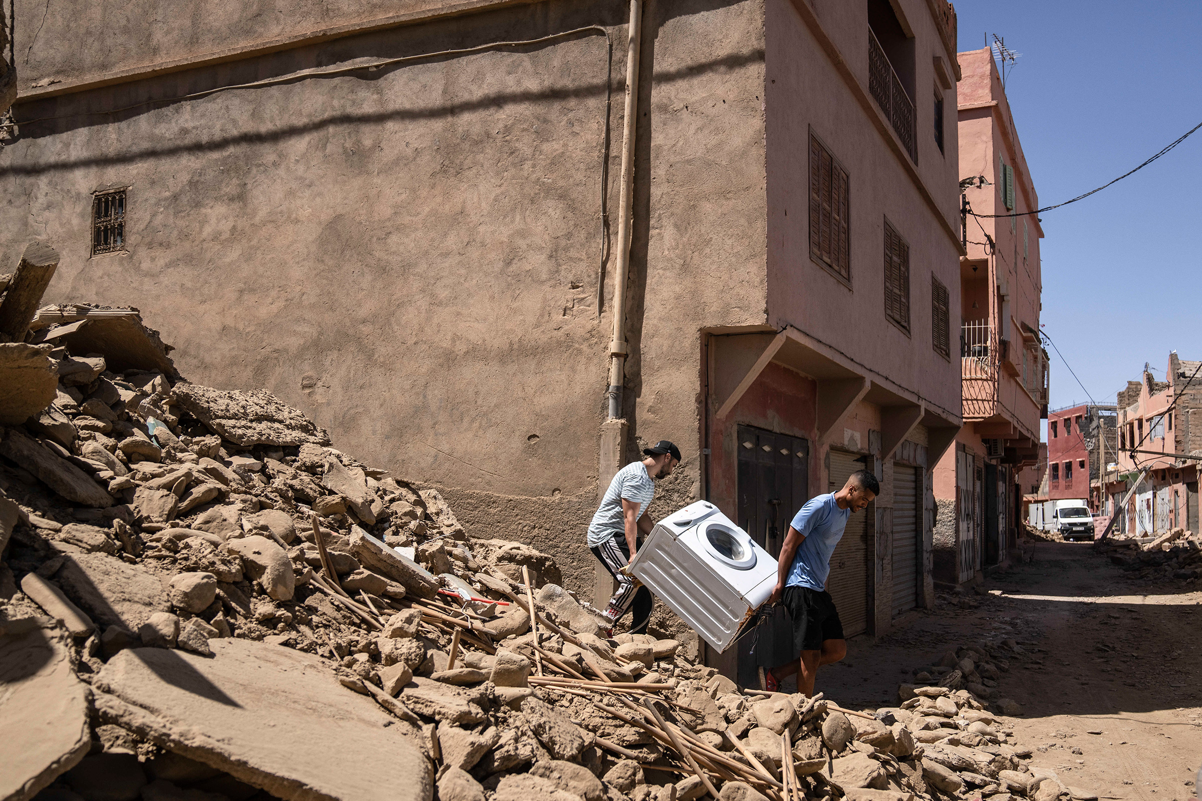 People recover a washing machine from their home that was damaged by the earthquake, in the town of Amizmiz, near Marrakech, Morocco, on Sept. 10. An aftershock rattled Moroccans on Sunday as they prayed for victims of the nation’s strongest earthquake in more than a century and toiled to rescue survivors while soldiers and workers brought water and supplies to desperate mountain villages in ruins. 