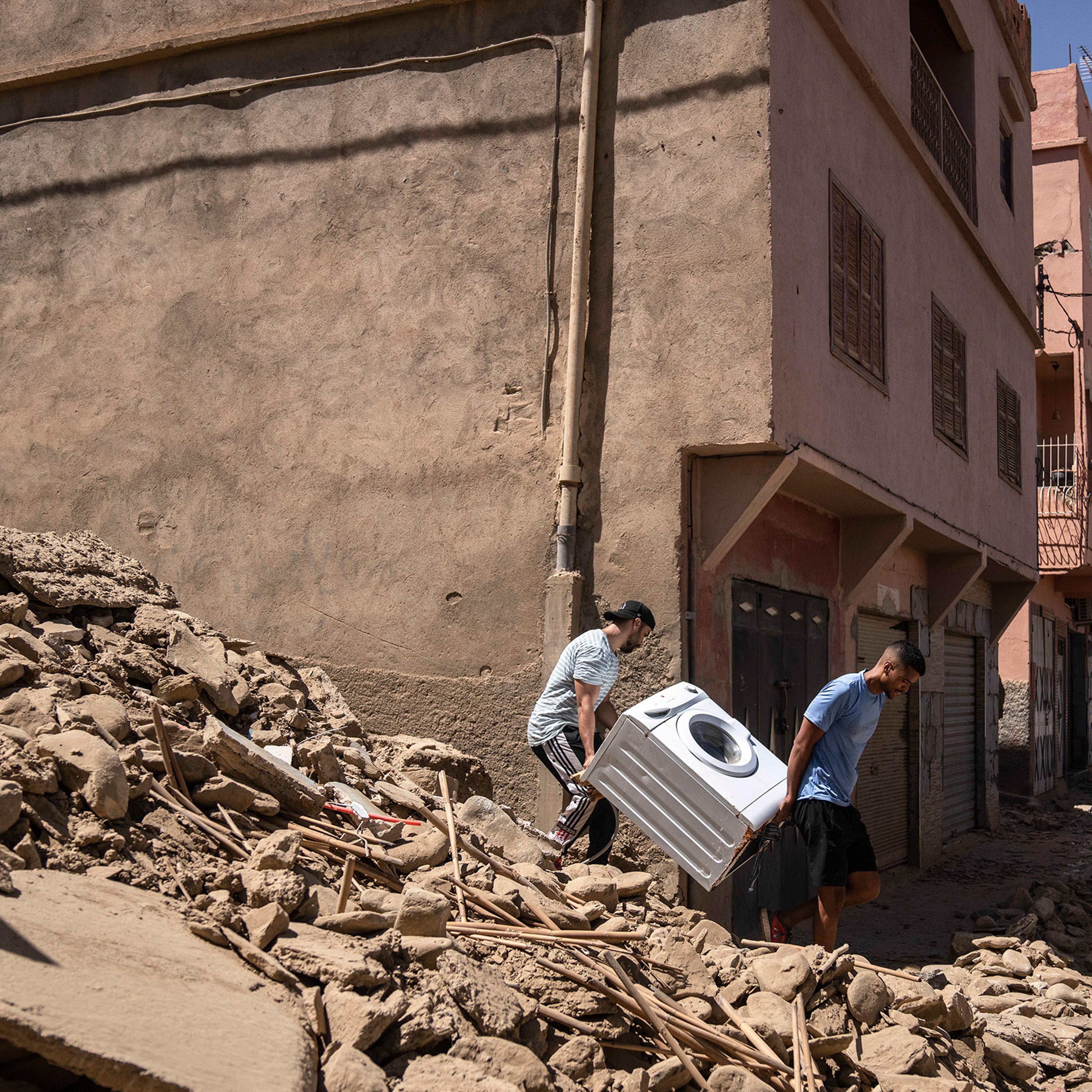People recover a washing machine from their home that was damaged by the earthquake, in the town of Amizmiz, near Marrakech, Morocco, on Sept. 10. An aftershock rattled Moroccans on Sunday as they prayed for victims of the nation’s strongest earthquake in more than a century and toiled to rescue survivors while soldiers and workers brought water and supplies to desperate mountain villages in ruins.