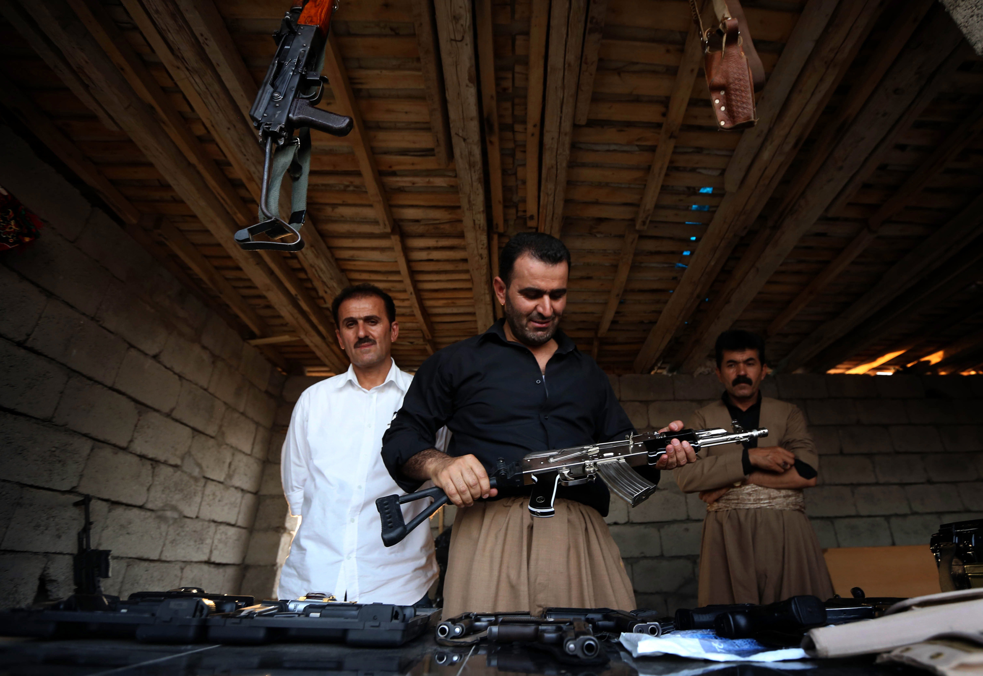An Iraqi Kurd inspects a machine gun at an arms market in Erbil, the capital of the autonomous Kurdish region of northern Iraq on Aug. 17, 2014.
