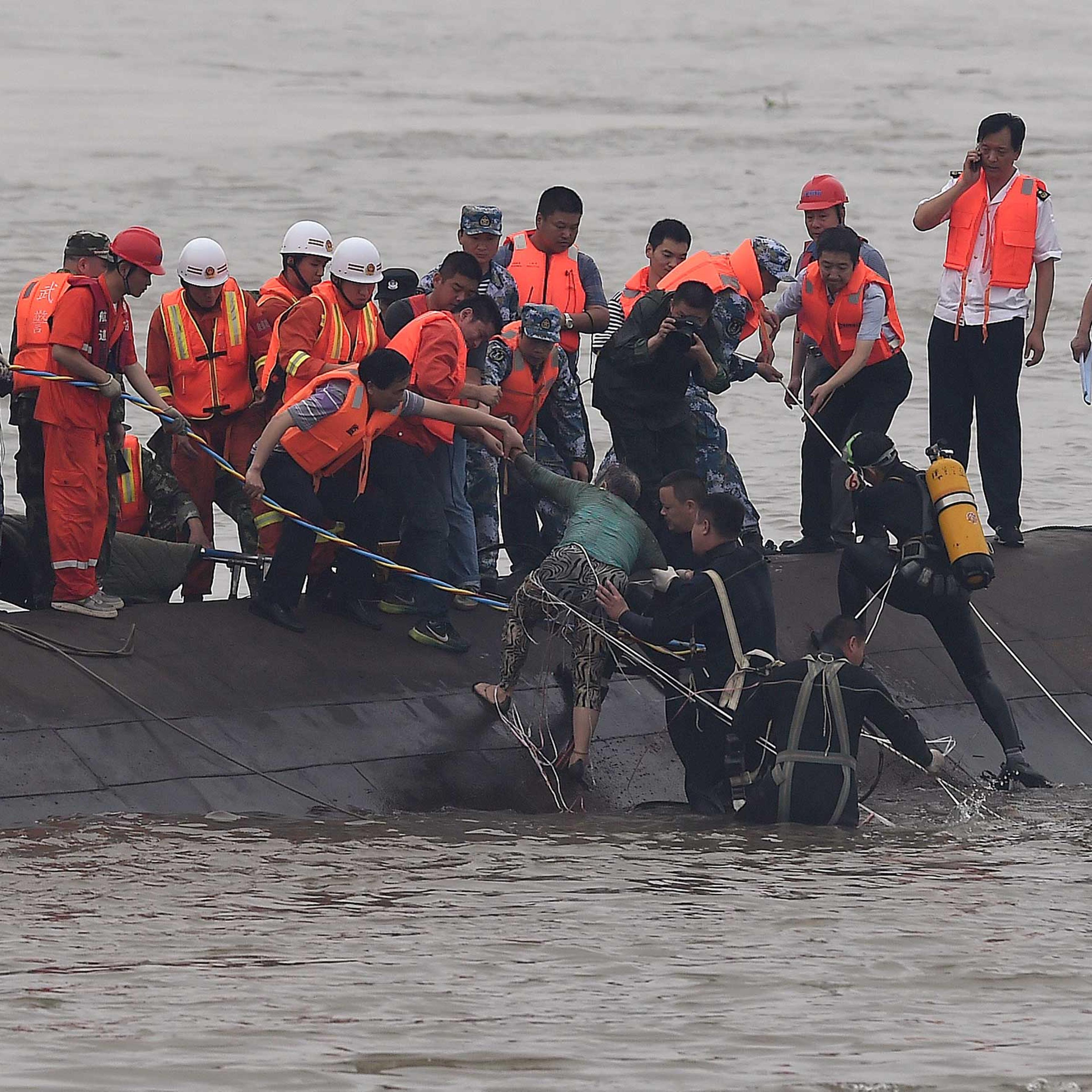 Rescuers save a survivor, center, from the overturned passenger ship in the Jianli section of the Yangtze River in central China's Hubei Province on June 2, 2015.