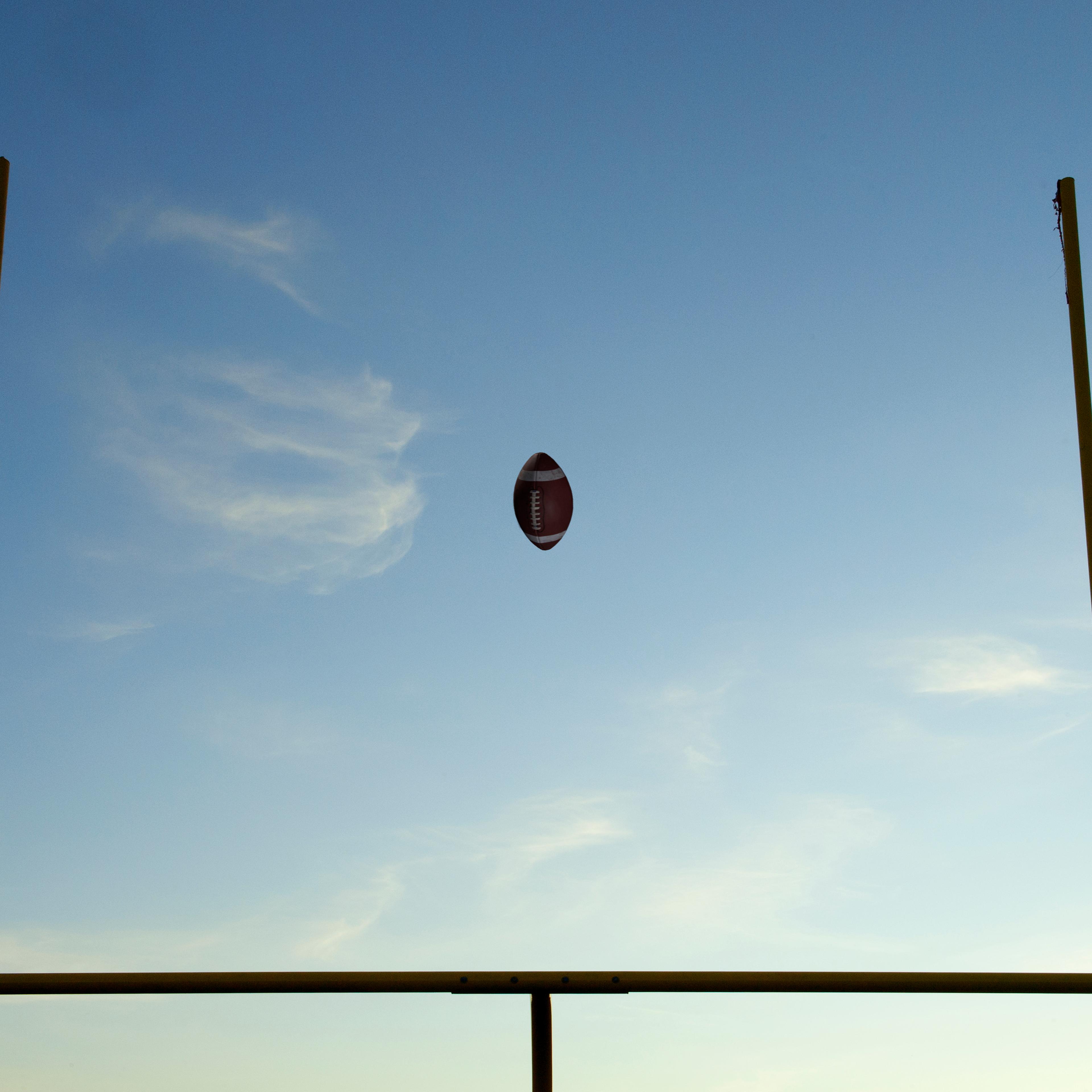 Football being thrown through goal posts