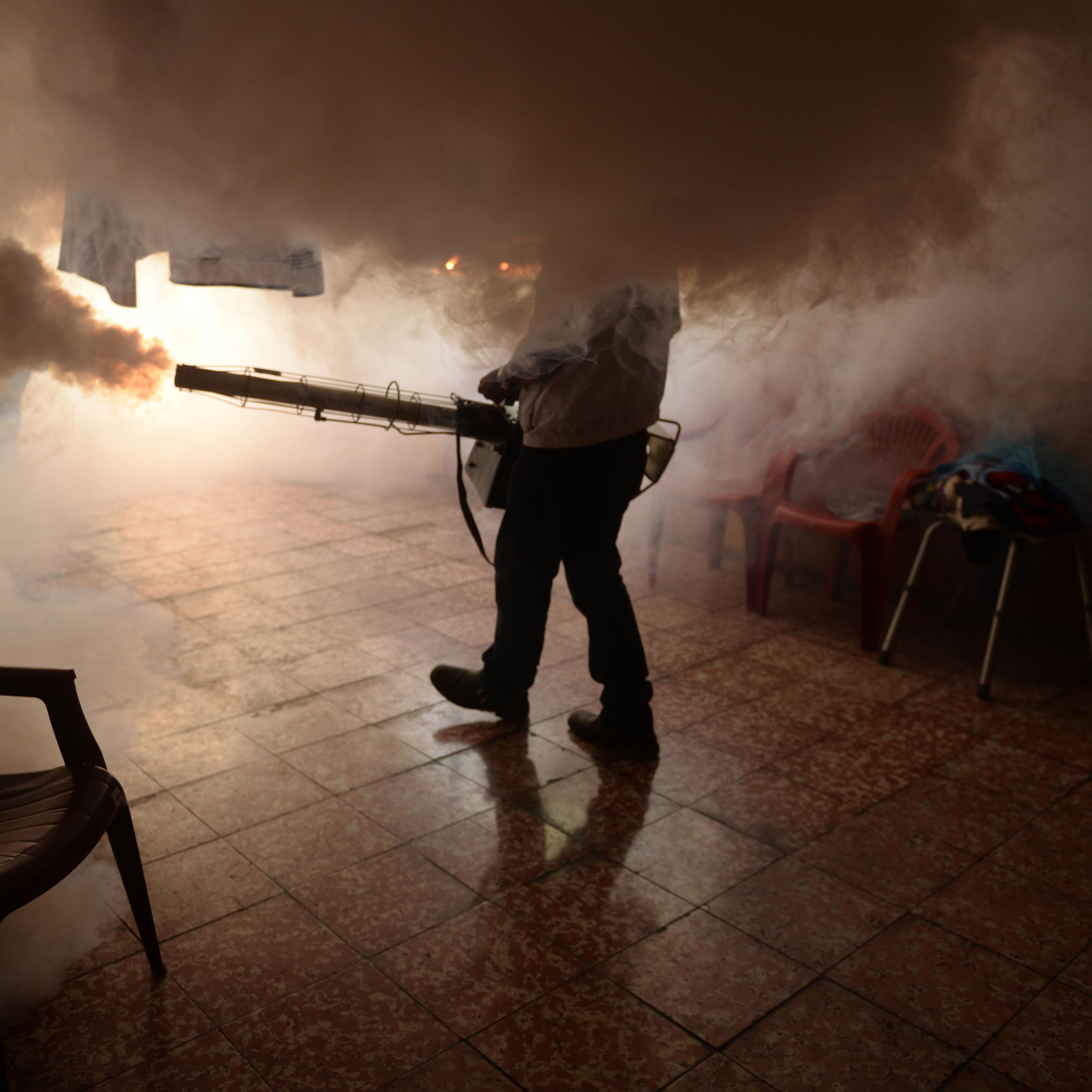 A Health Ministry employee fumigates a home against to prevent the spread of the Zika virus in Soyapango, easy of San Salvador, on Jan. 21, 2016.