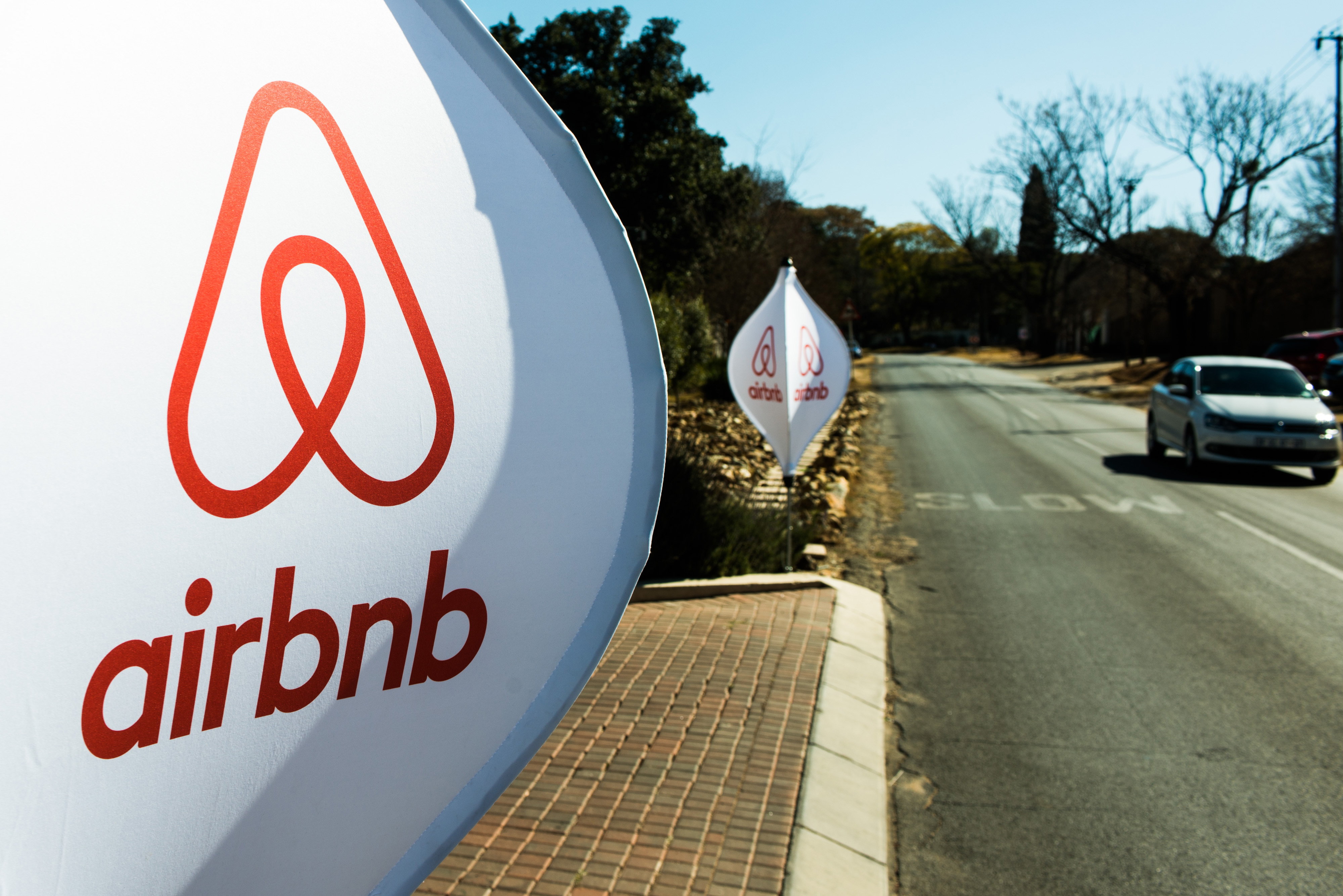 The logos of Airbnb sit on banners displayed outside a media event in Johannesburg on July 27, 2015 