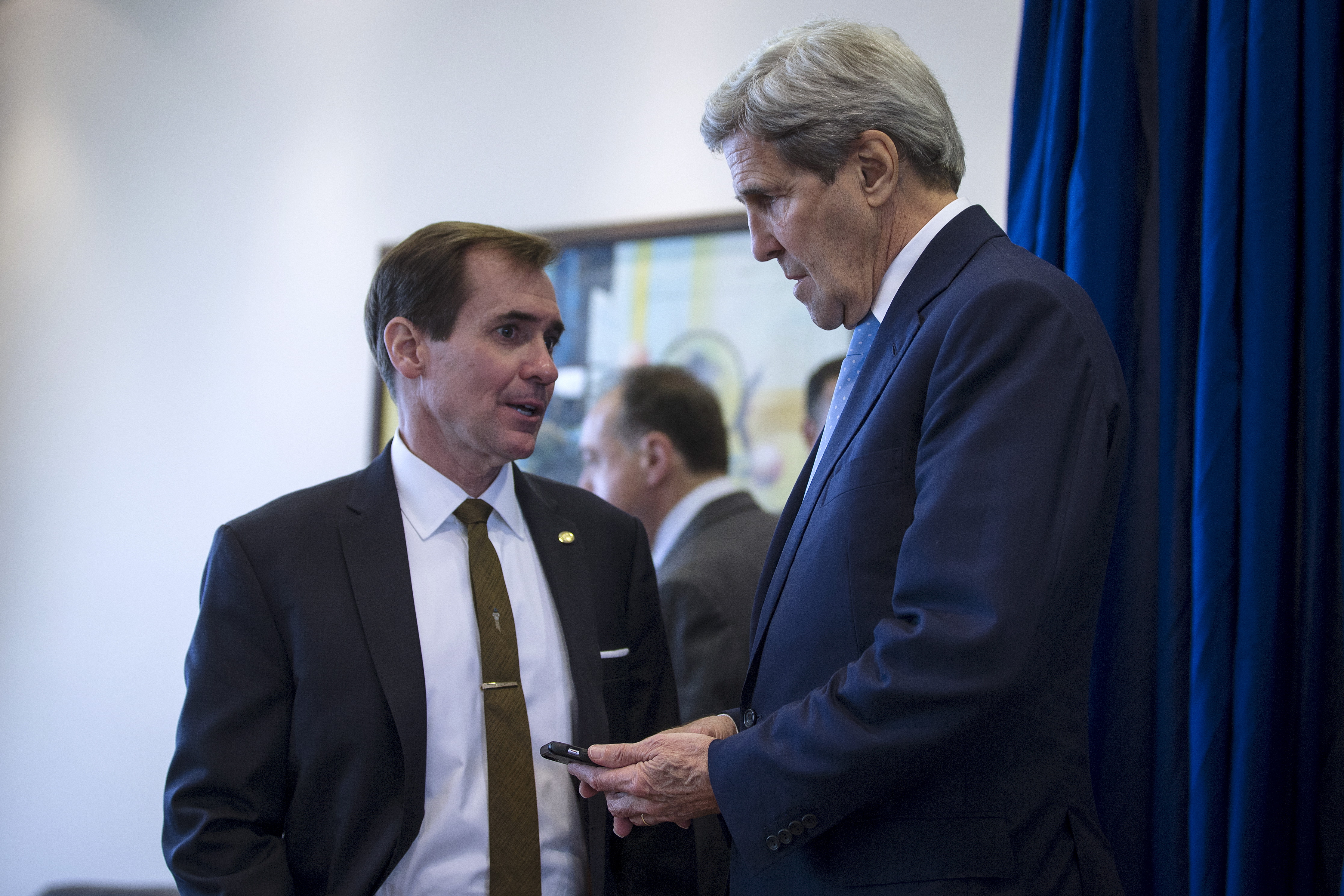 U.S. Secretary of State John Kerry speaks to senior advisor John Kirby before he holds a briefing at Amman Civil Airport in Amman