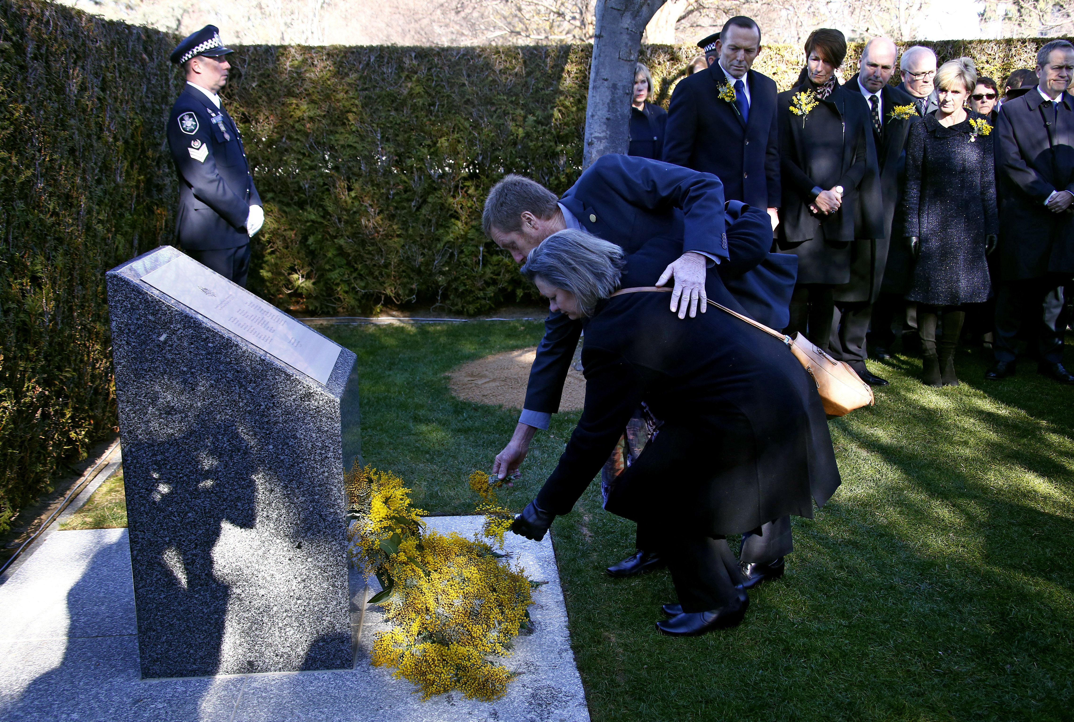 Relatives of the Australian victims of Malaysia Airlines flight MH17 place floral tributes at a memorial unveiled on the first anniversary of the plane's downing, outside Parliament House in Canberra on July 17, 2015.