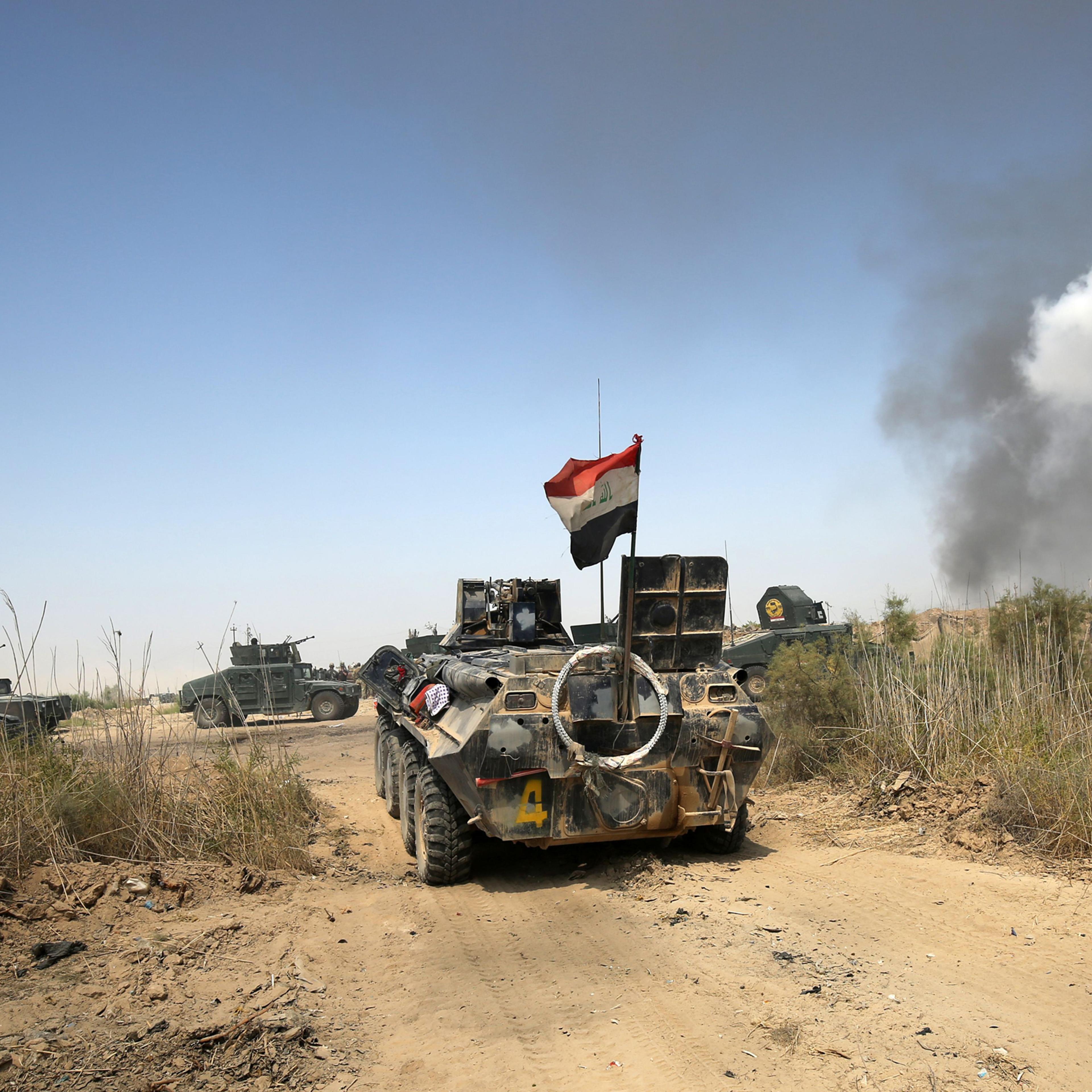 Iraqi government forces drive their armoured vehicles during an operation, backed by air support from the US-led coalition, in Fallujah's southern Shuhada neighbourhood to retake the area from the Islamic State (IS) group on June 15, 2016.