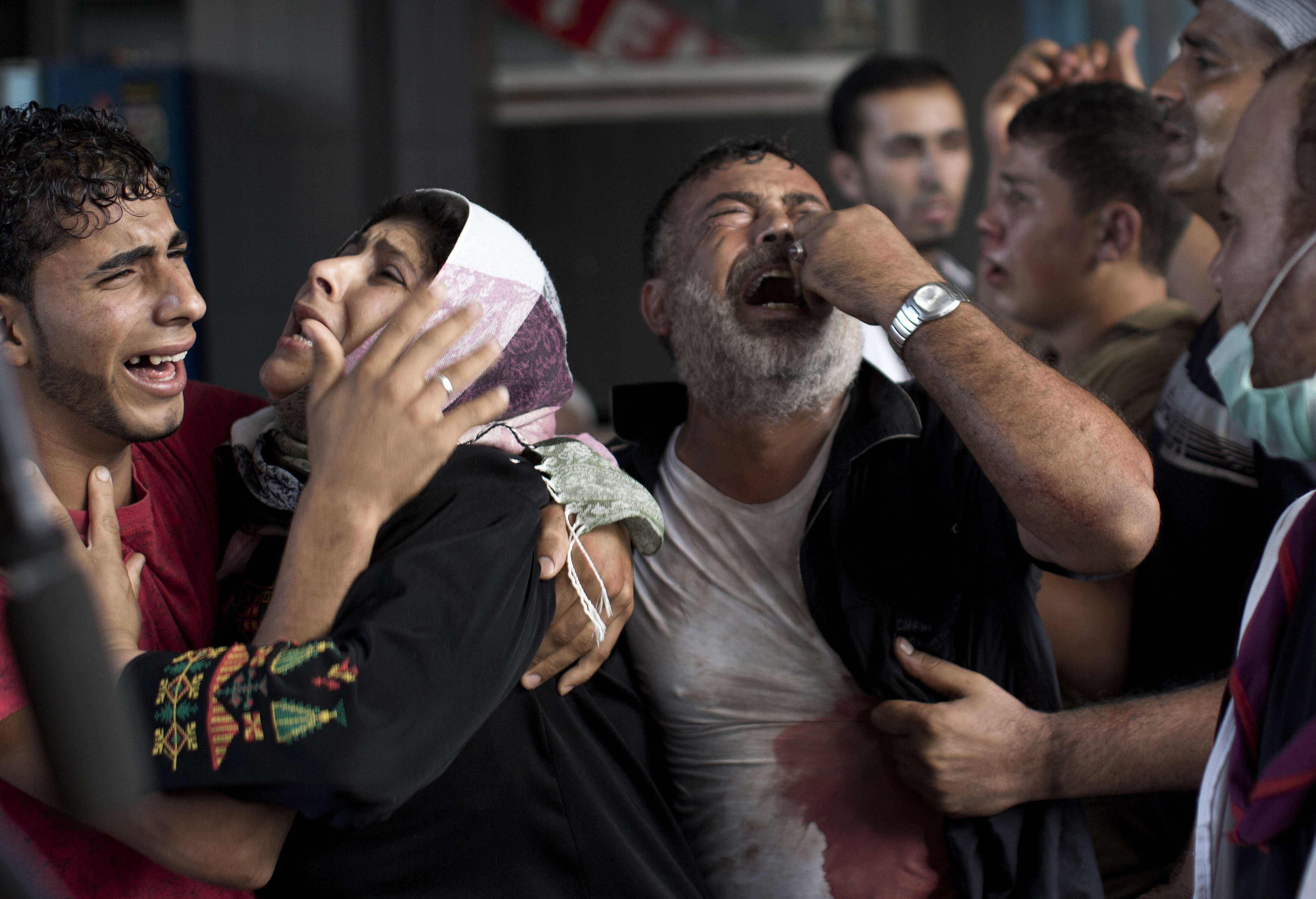 Palestinian mourners cry at Gaza City's al-Shifa hospital after an explosion killed at least seven children in a public playground in the beachfront Shati refugee camp on July 28, 2014.