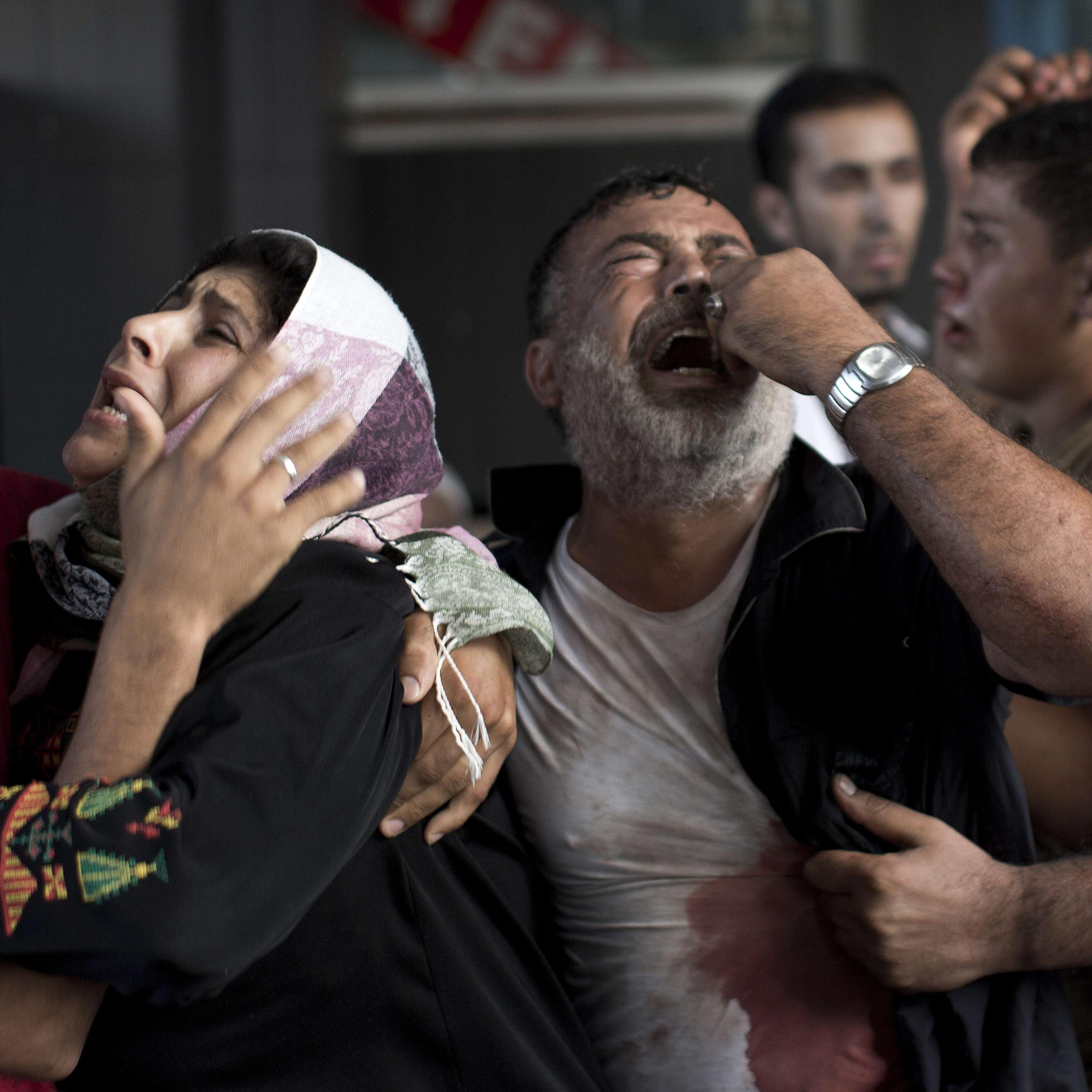 Palestinian mourners cry at Gaza City's al-Shifa hospital after an explosion killed at least seven children in a public playground in the beachfront Shati refugee camp on July 28, 2014.