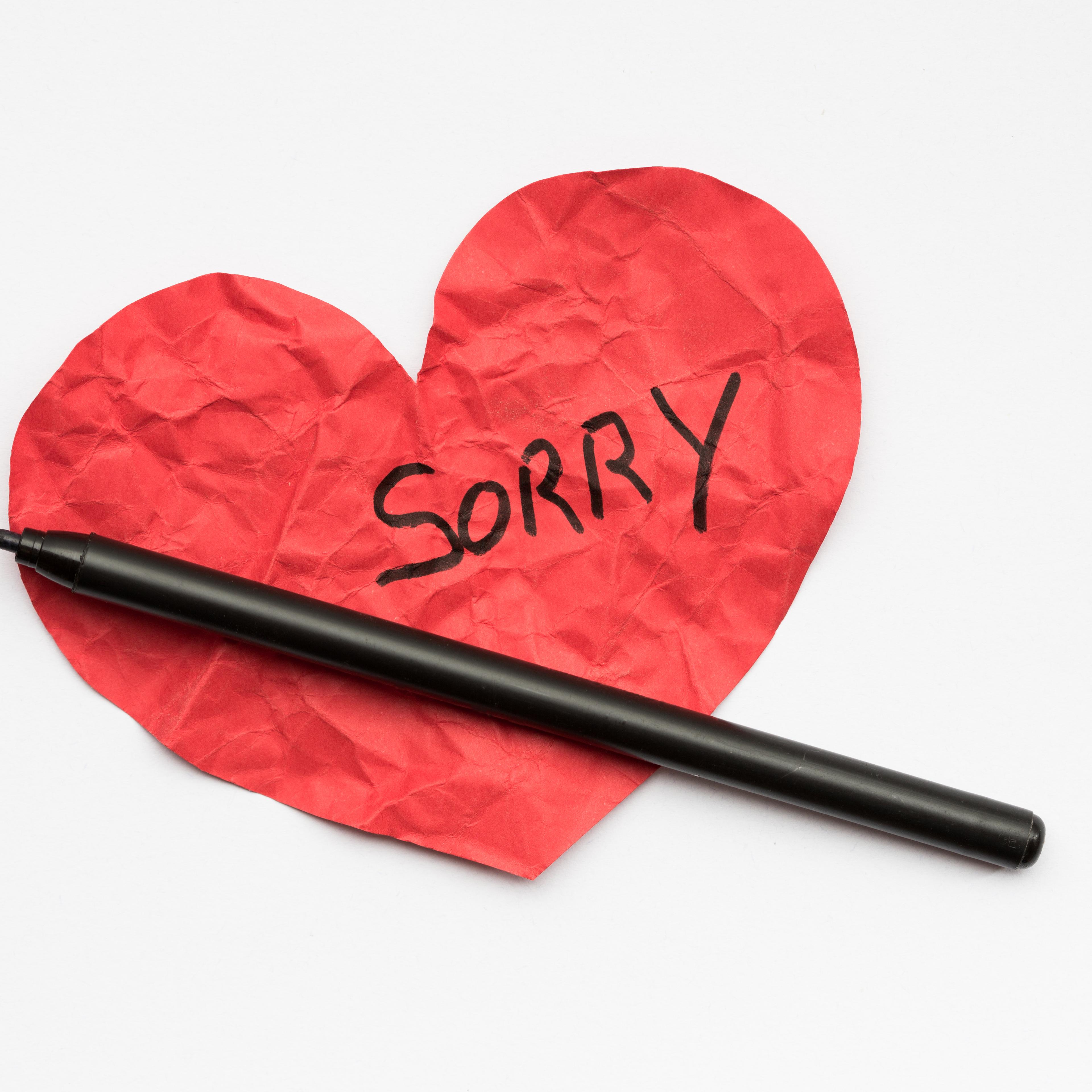 Crumpled red paper heart with pen