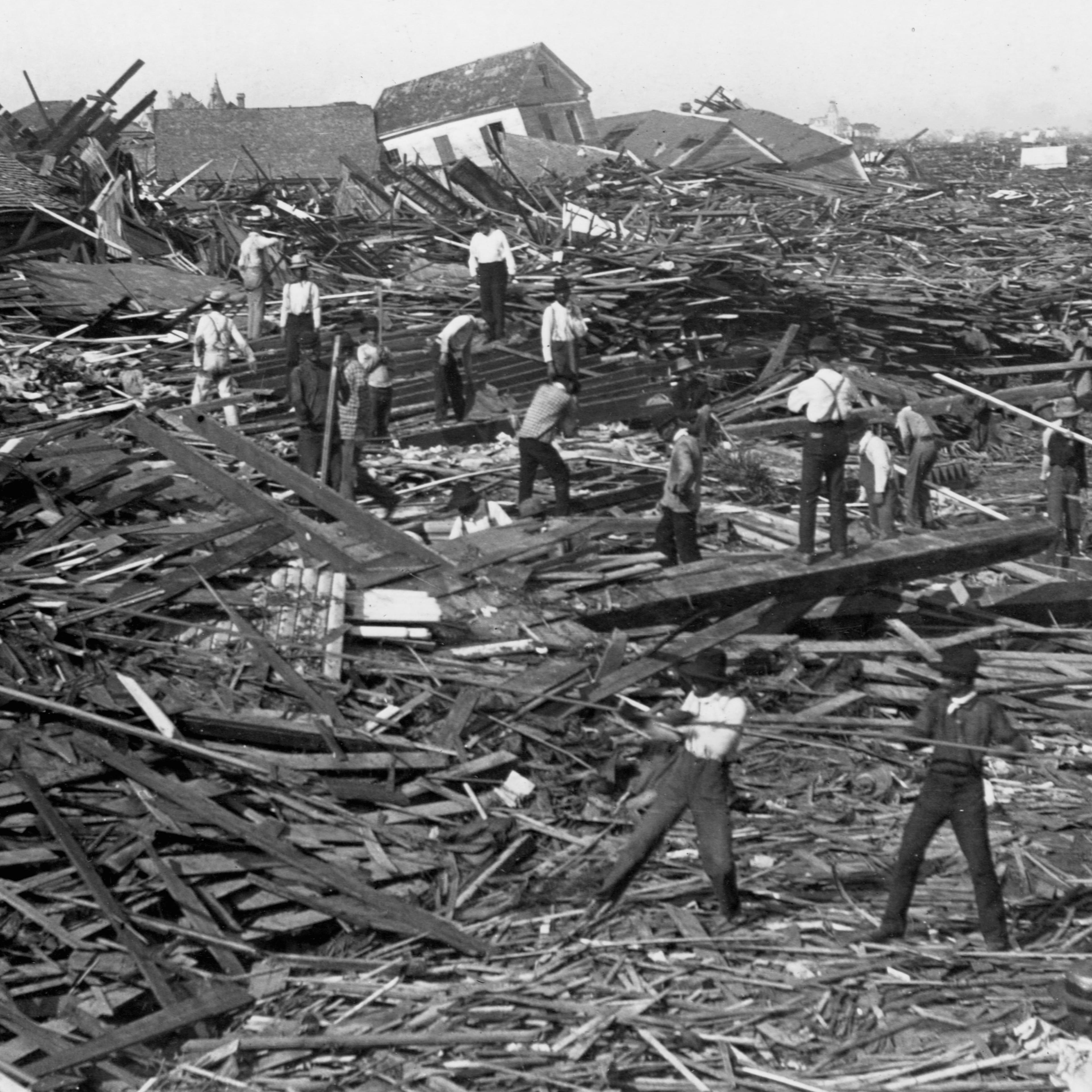 Men use ropes to pull away the debris of houses in order to look for bodies, after the Galveston Hurricane of 1900.