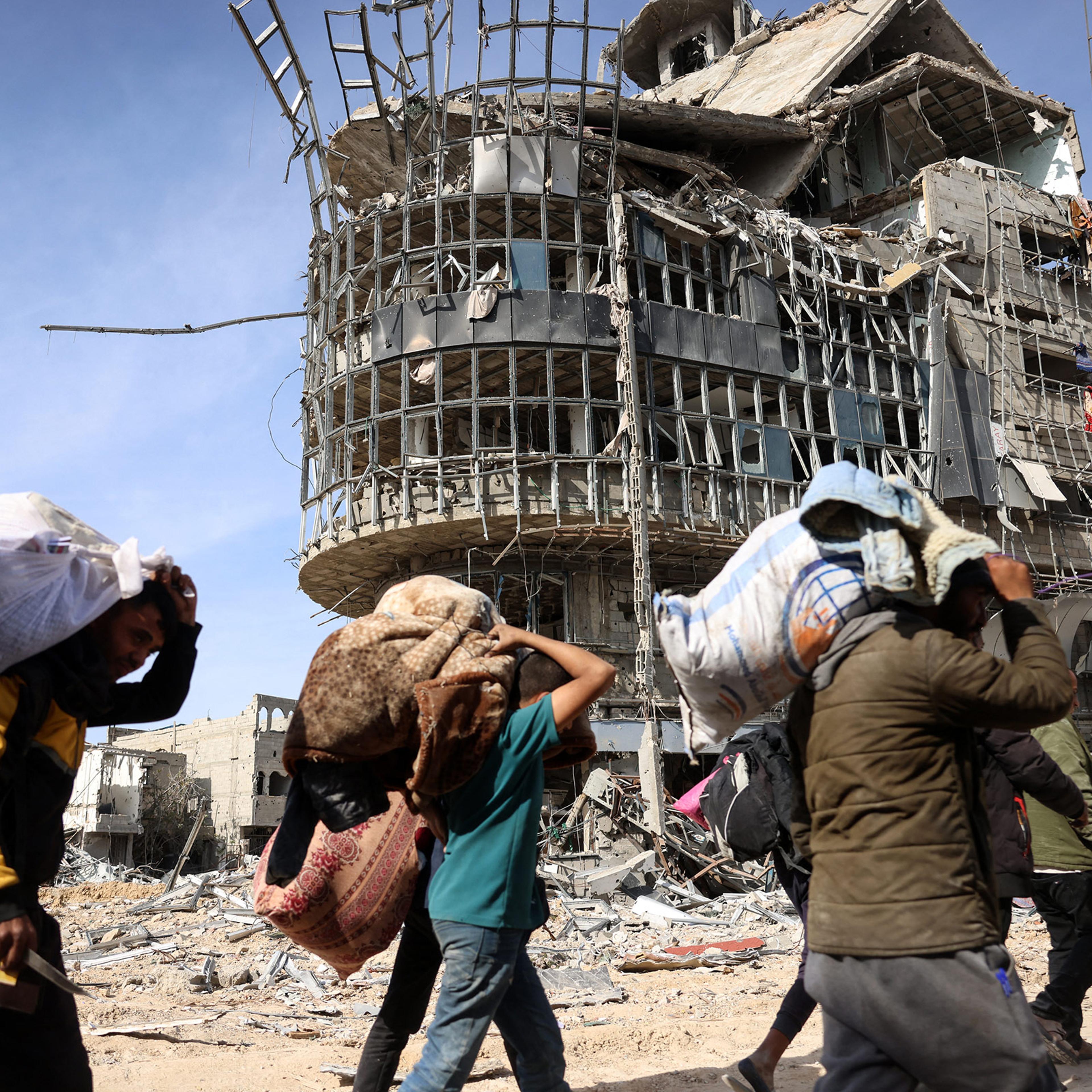 Displaced Palestinians carry their belongings as they walk amid the devastation upon their return to central Rafah in the southern Gaza Strip on Jan. 19, 2025.