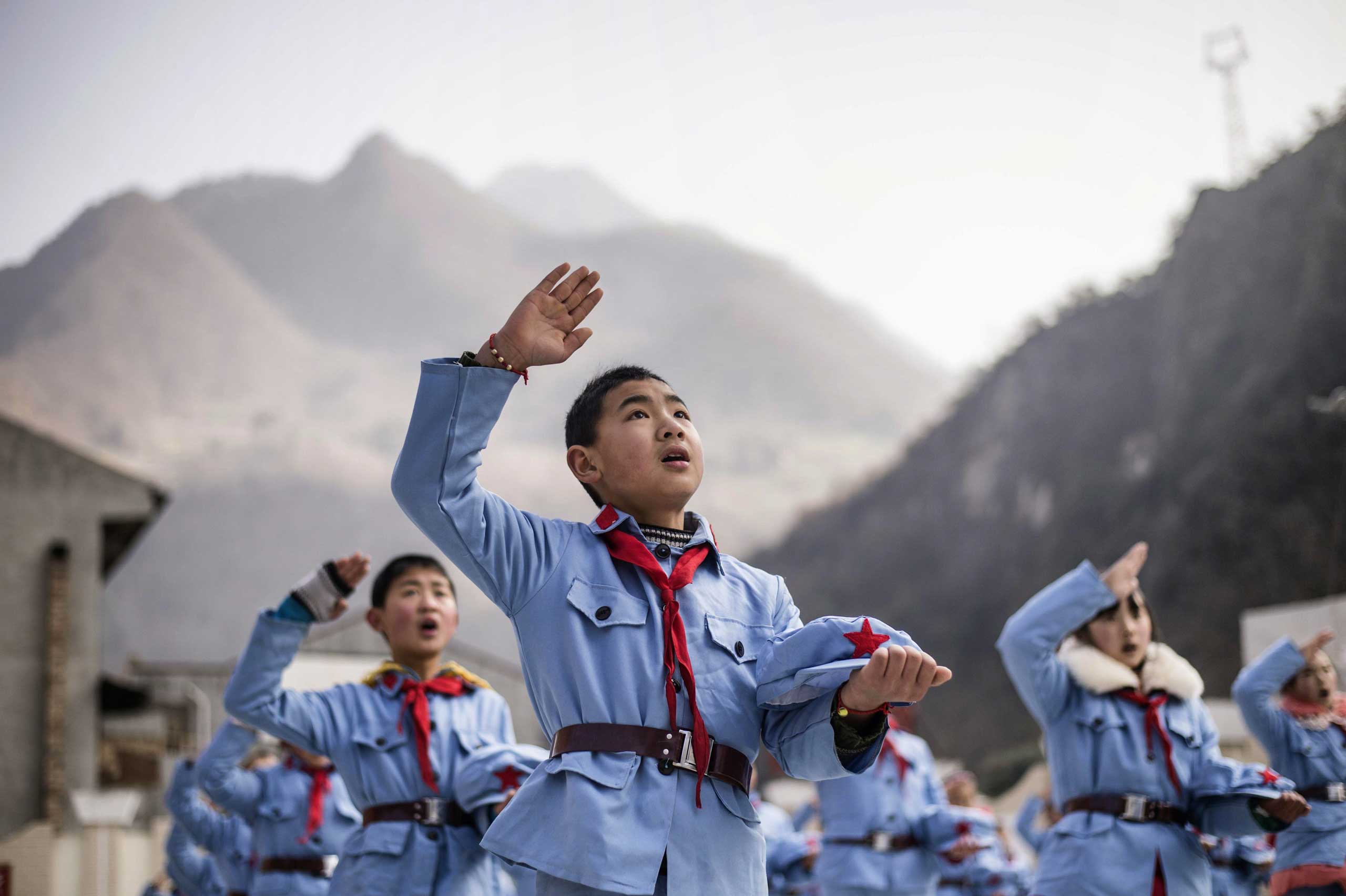 Children sing after raising the national flag.