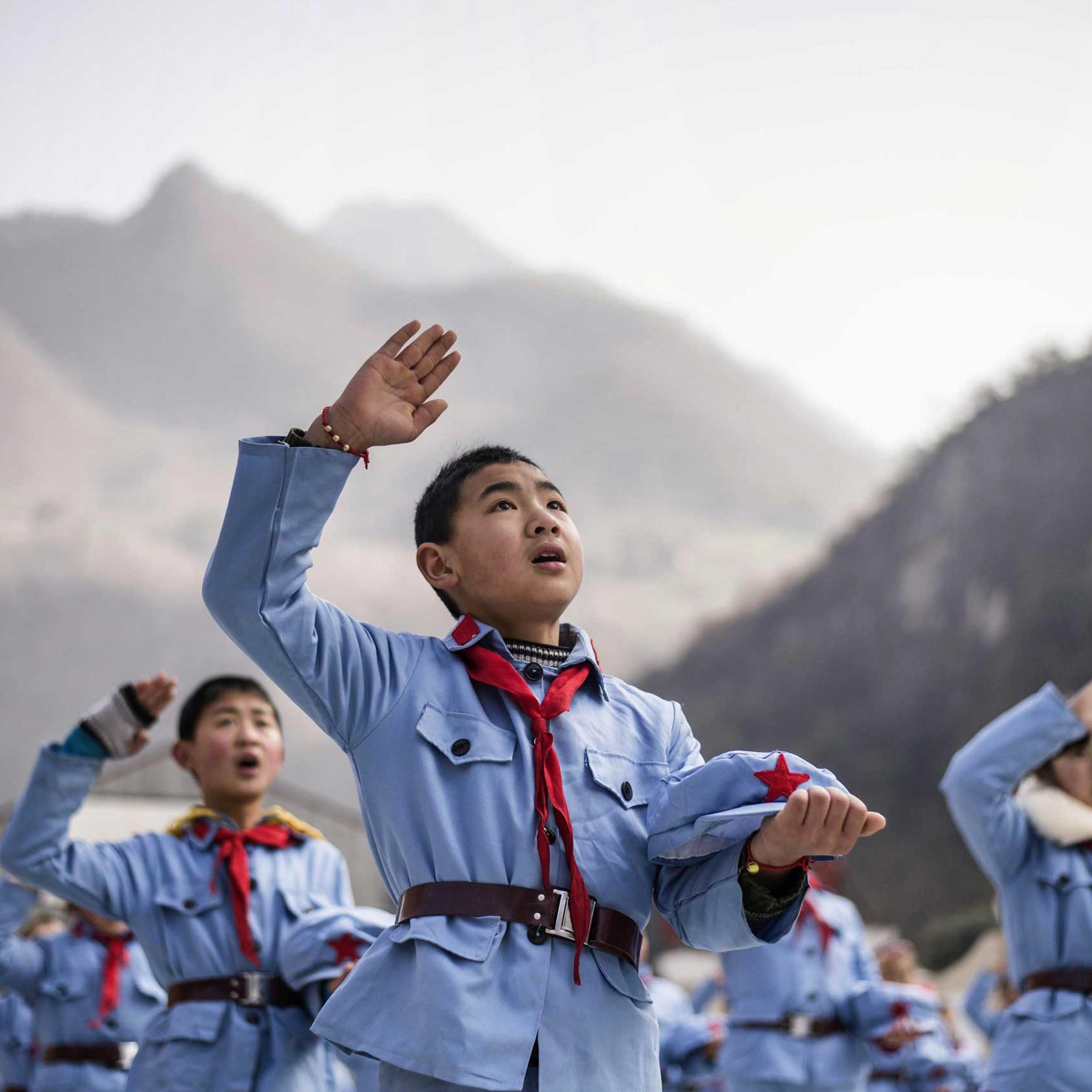 Children sing after raising the national flag.