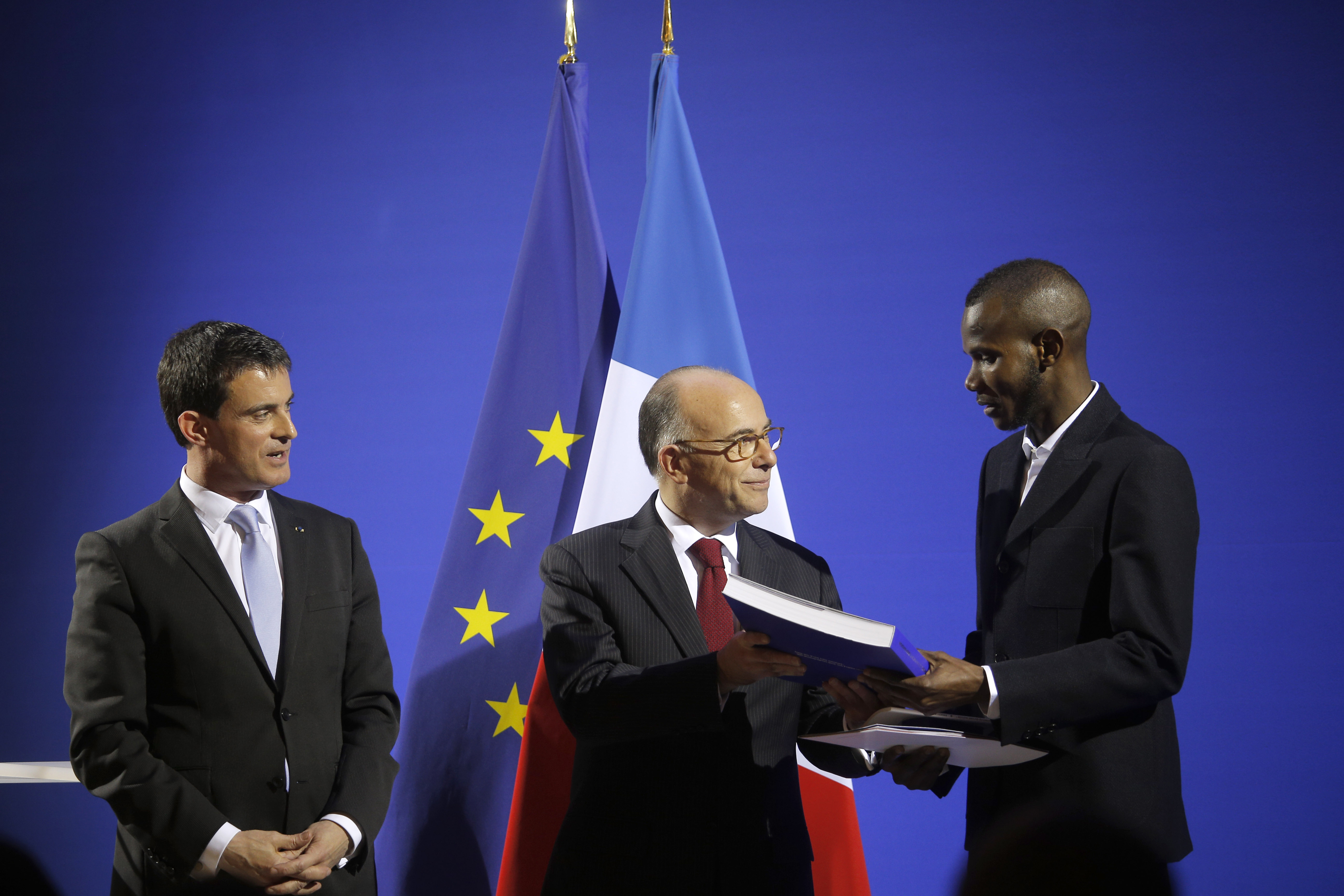 French Prime Minister Manuel Valls (L) and French Interior Minister Bernard Cazeneuve (C) award citizenship to Lassana Bathily in Paris, France, on Jan. 20, 2015.