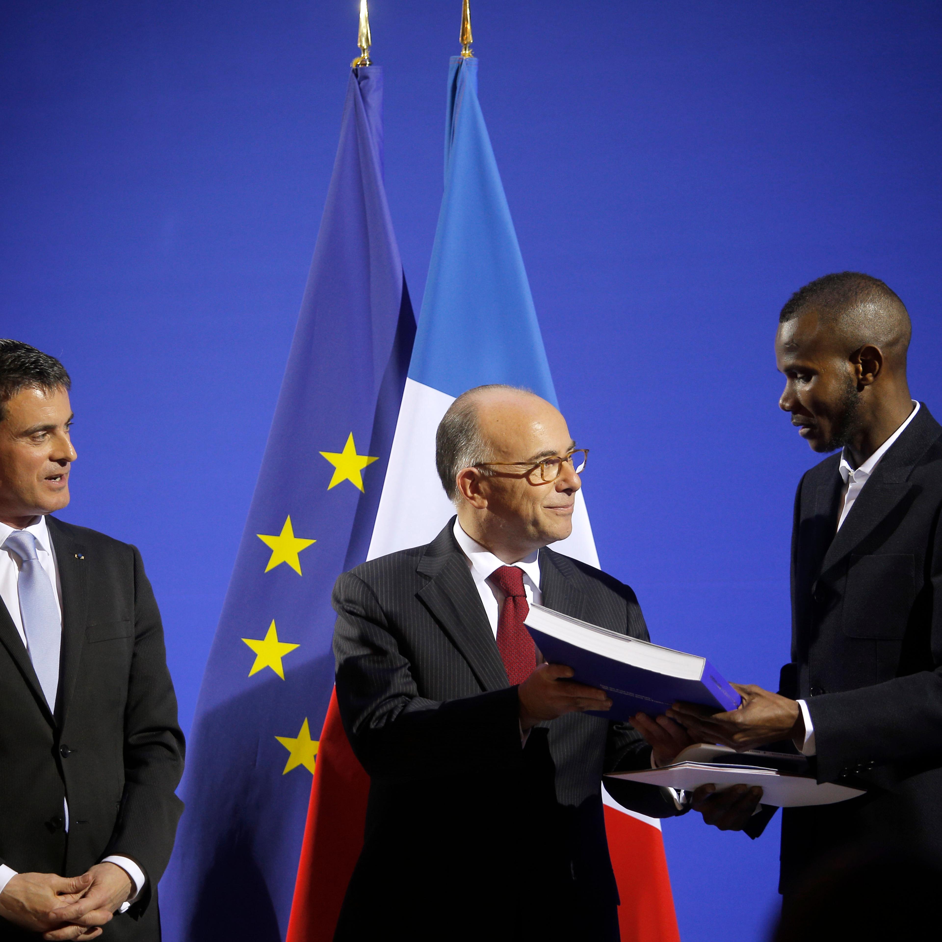 French Prime Minister Manuel Valls (L) and French Interior Minister Bernard Cazeneuve (C) award citizenship to Lassana Bathily in Paris, France, on Jan. 20, 2015.