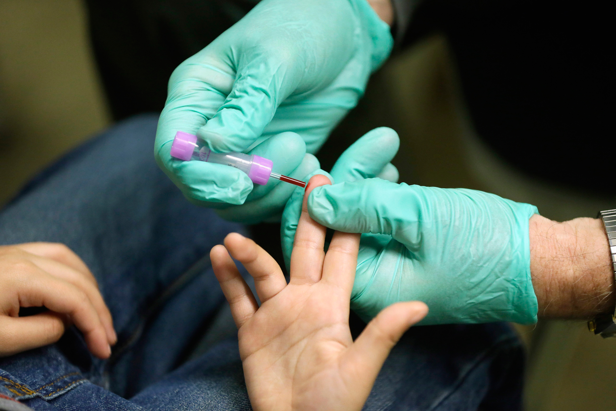 FILE - In this Jan. 26, 2016 file photo, registered nurse Brian Jones draws a blood sample from a student at Eisenhower Elementary School in Flint, Mich. The students were being tested for lead after the metal was found in the city's drinking water. Bloo