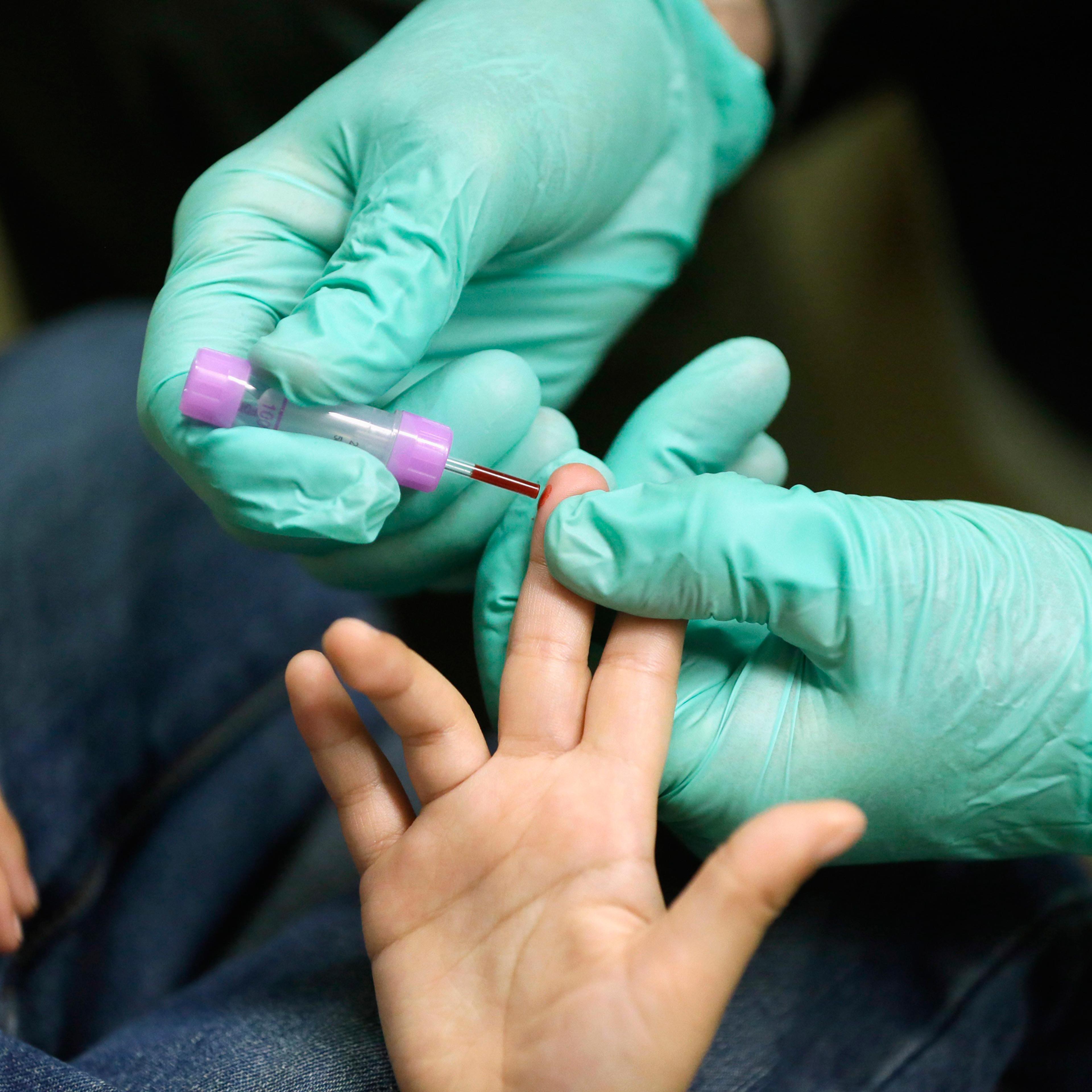 FILE - In this Jan. 26, 2016 file photo, registered nurse Brian Jones draws a blood sample from a student at Eisenhower Elementary School in Flint, Mich. The students were being tested for lead after the metal was found in the city's drinking water. Bloo