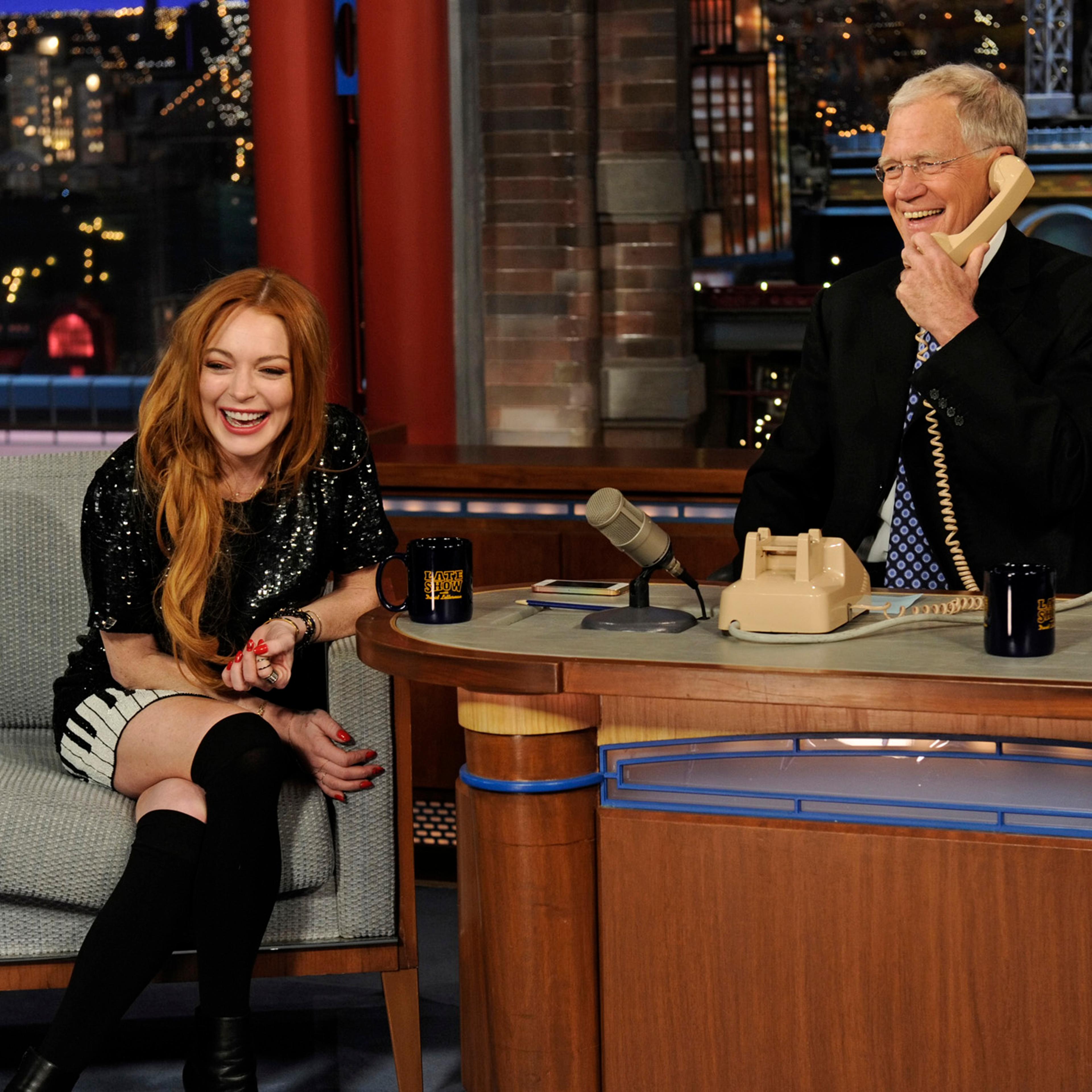 From right: David Letterman and Lindsay Lohan call Oprah Winfrey when Lohan visits the Late Show with David Letterman on April 9, 2014 in New York City.