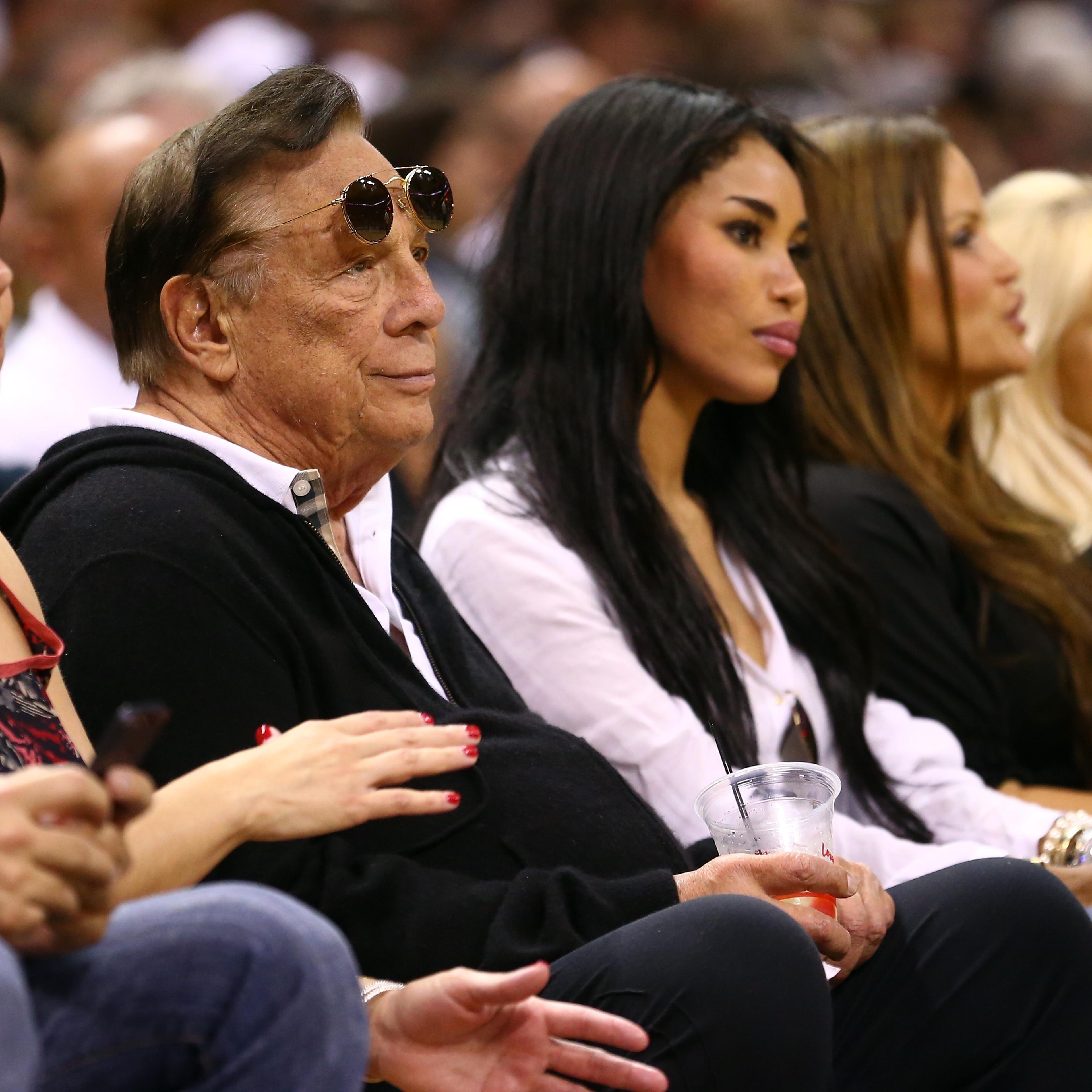 Team owner Donald Sterling (center) of the Los Angeles Clippers and V. Stiviano (second from right) watch the San Antonio Spurs play against the Memphis Grizzlies in San Antonio on May 19, 2013.
