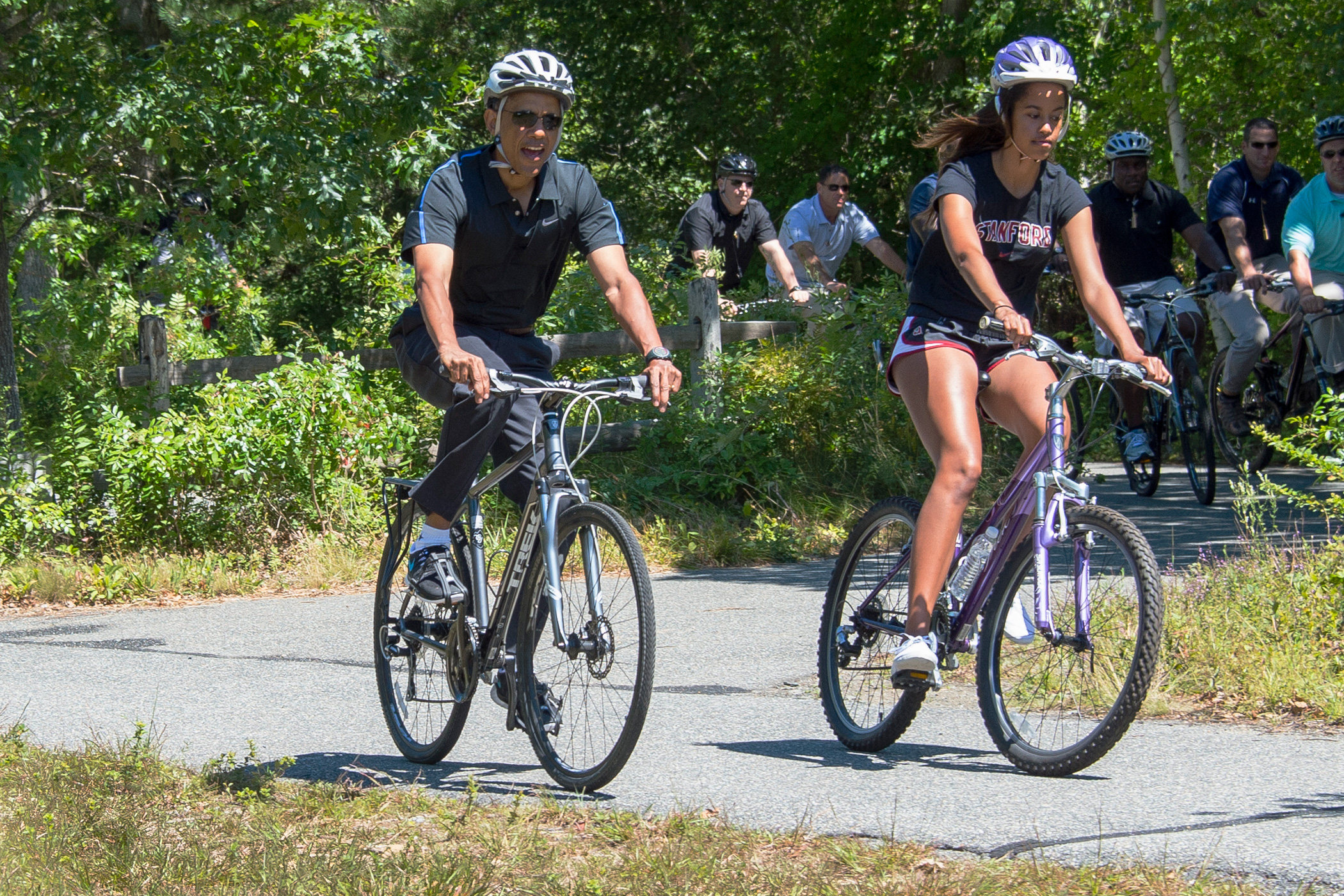 Aug. 15, 2014 President Barack Obama and daughter Malia Obama ride bikes along the Correllus State Bike Path outside of West Tisbury, Martha's Vineyard, Mass.