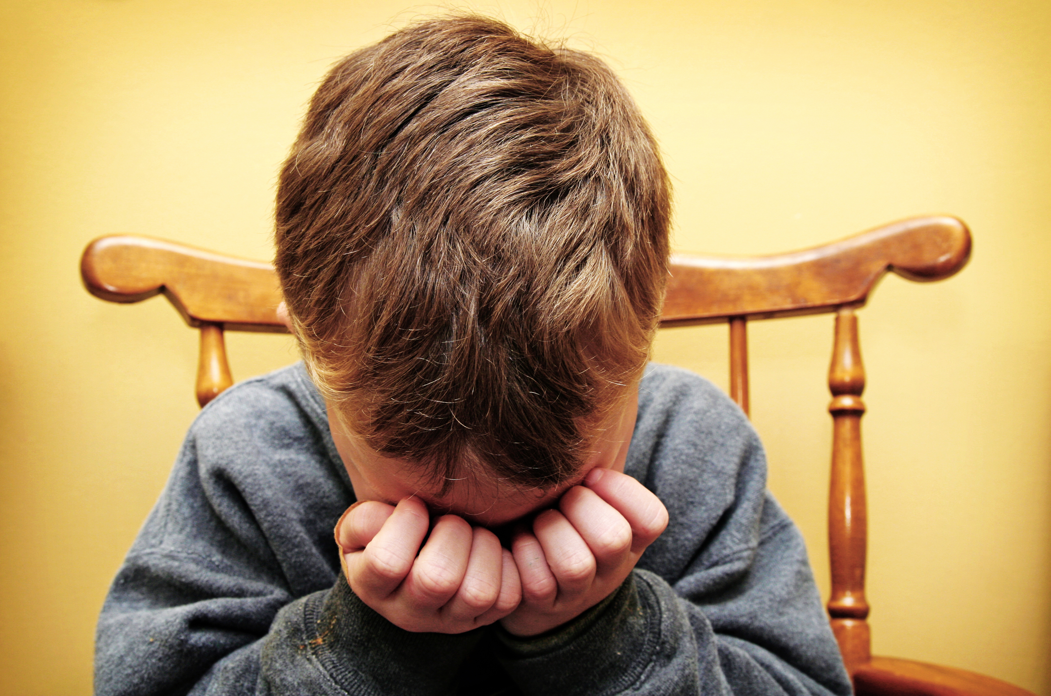 Young Boy Hides His Face In Tears