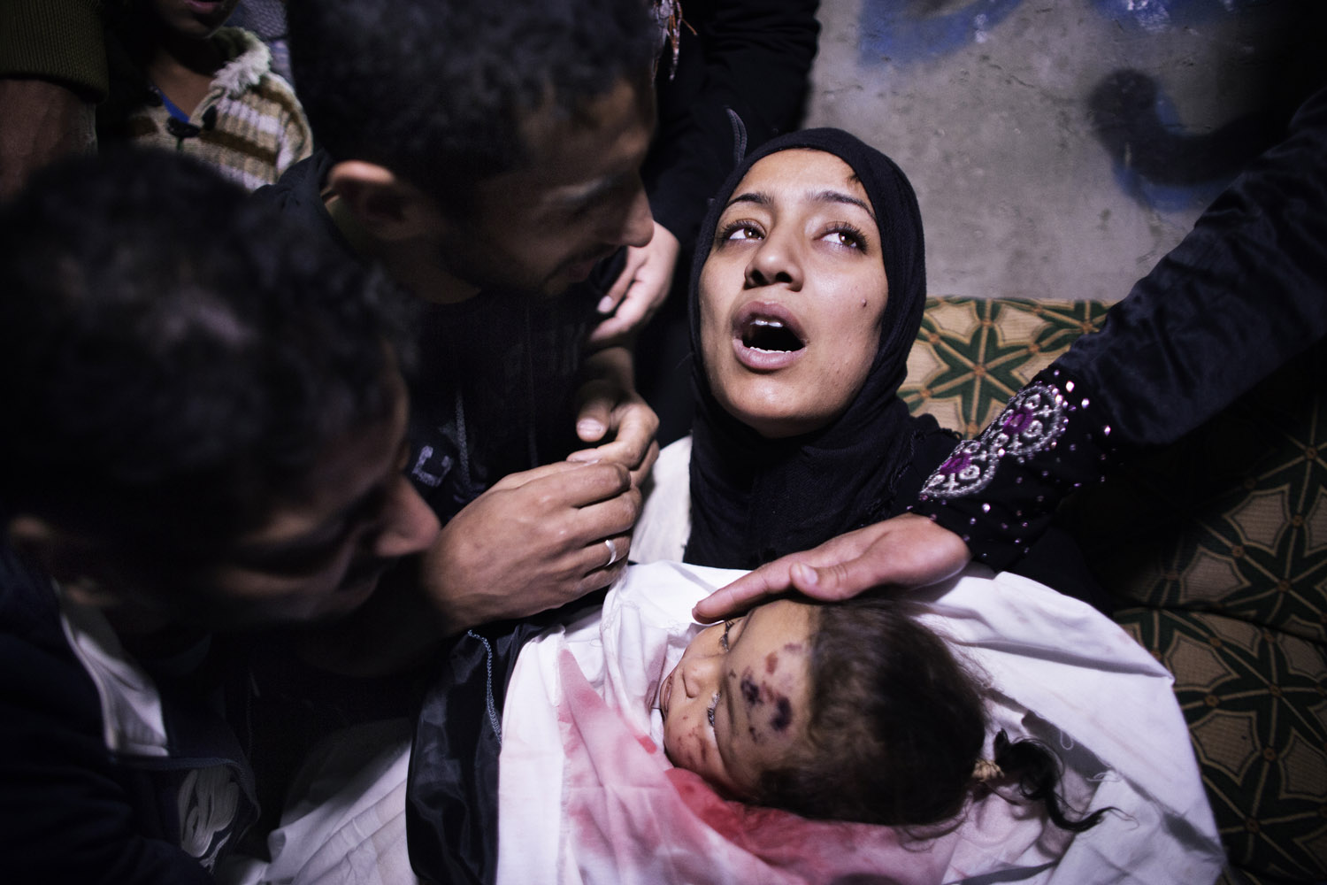Nov. 16, 2012. The mother of a 10-month-old Palestinian girl killed the day before in an Israeli air strike is comforted by her husband and relatives as she mourns before her daughter's funeral in Gaza City.