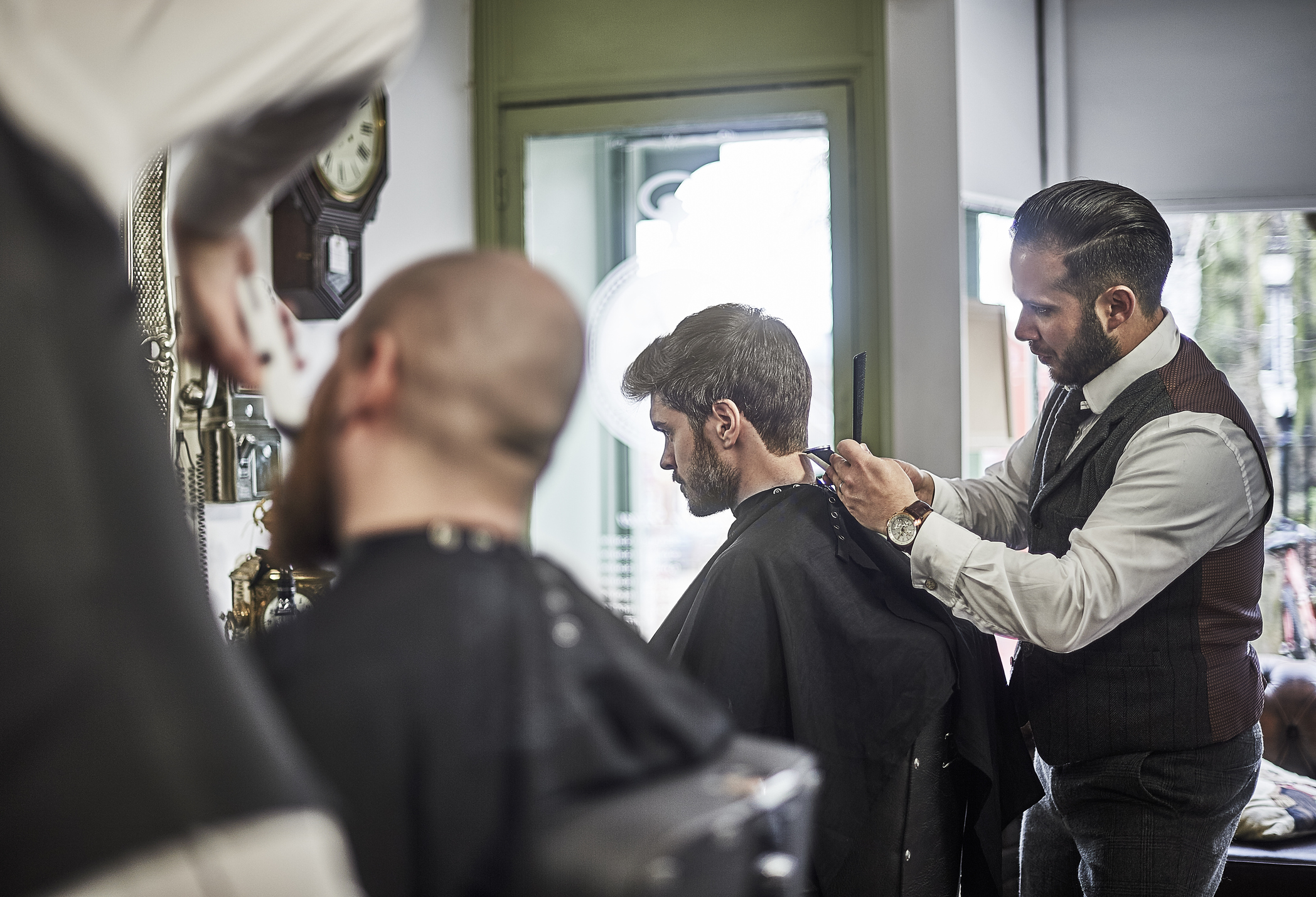Male barber perfecting hair cut