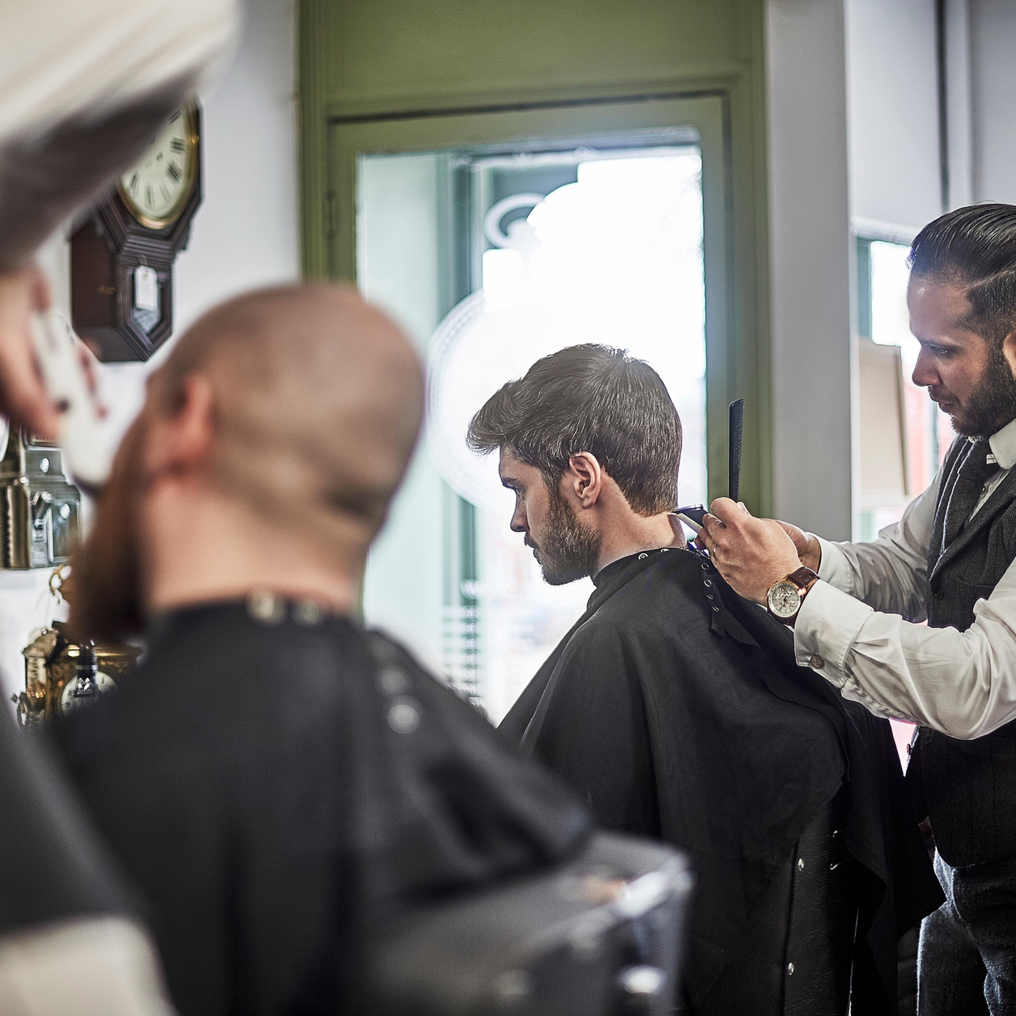 Male barber perfecting hair cut