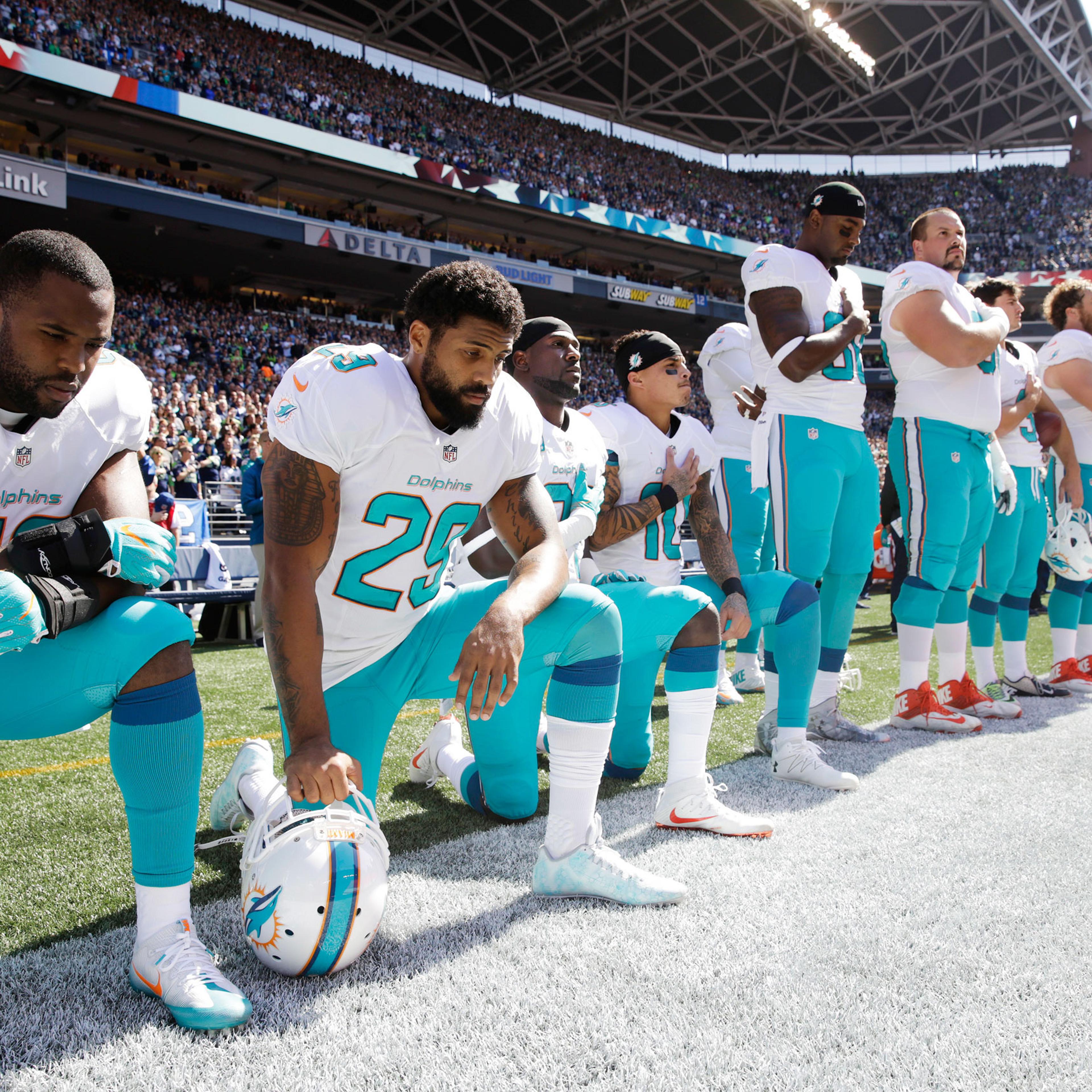 From left, Miami Dolphins Jelani Jenkins, Arian Foster, Michael Thomas and Kenny Stills kneel during the national anthem on Sept. 11