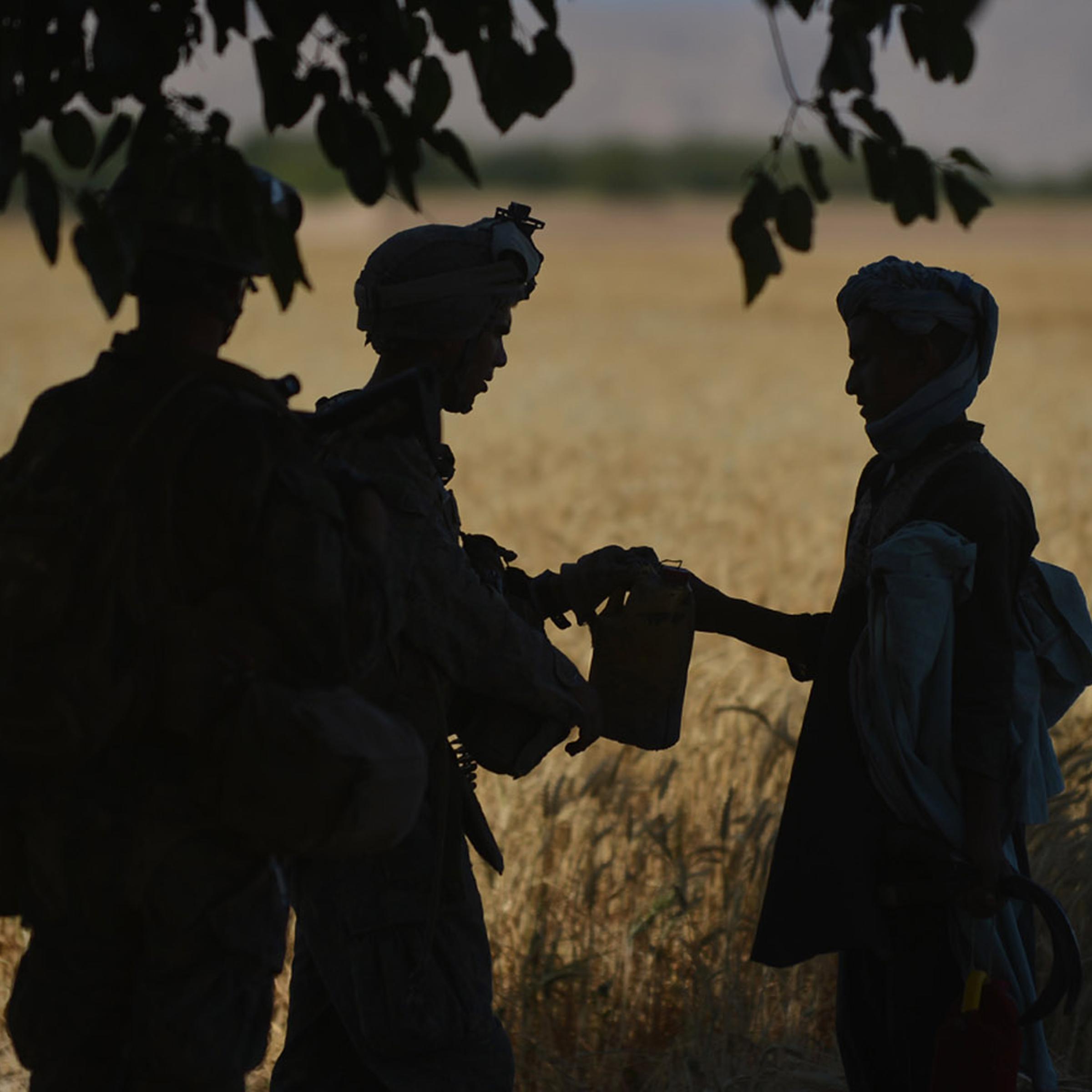 June 10, 2012. U.S. Marines check a farmer while in Sangin in Afghanistan.