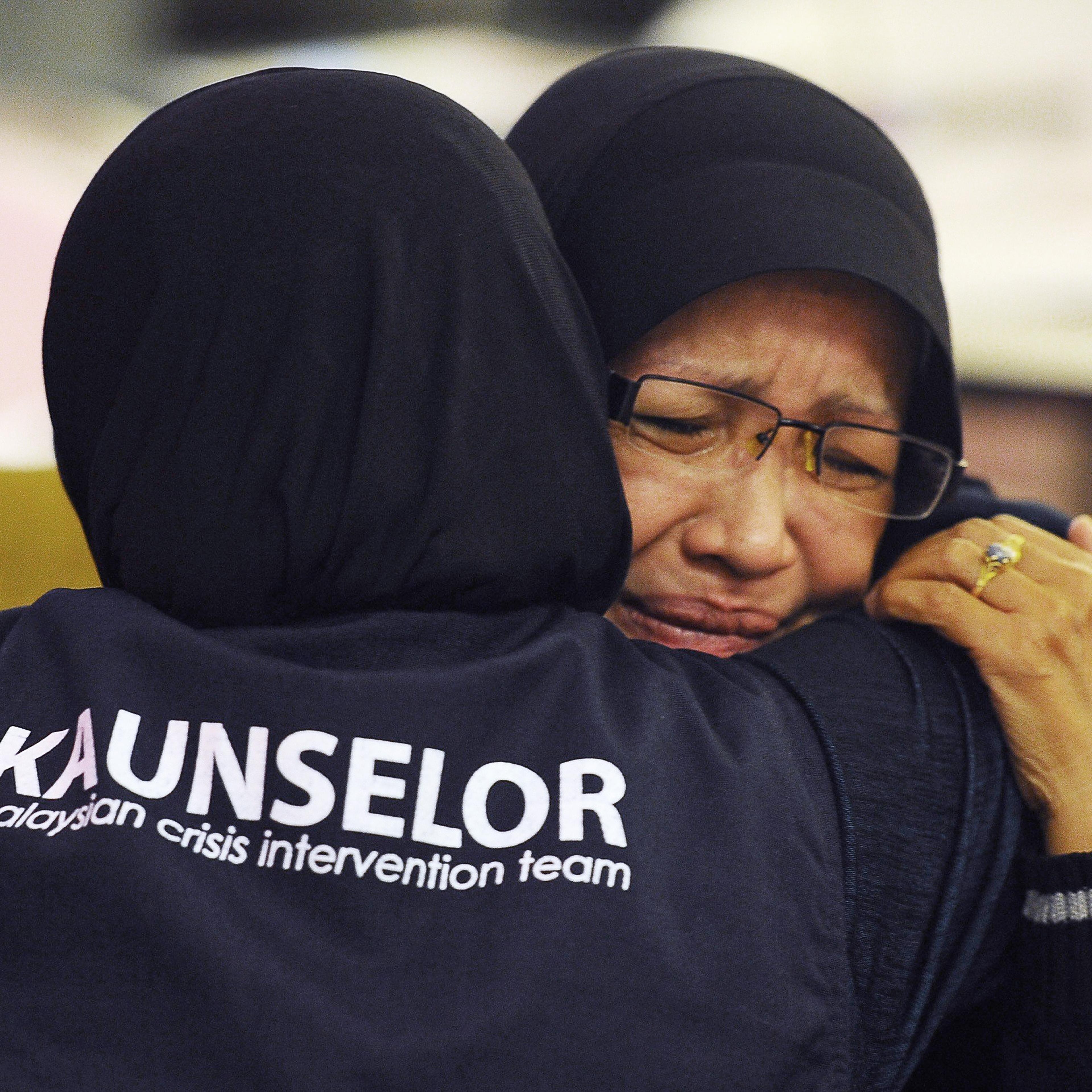 A family member of one of the passengers aboard a missing plane is consoled by a crisis counselor at a hotel in Putrjaya, outside Kuala Lumpur, on March 9, 2014.
