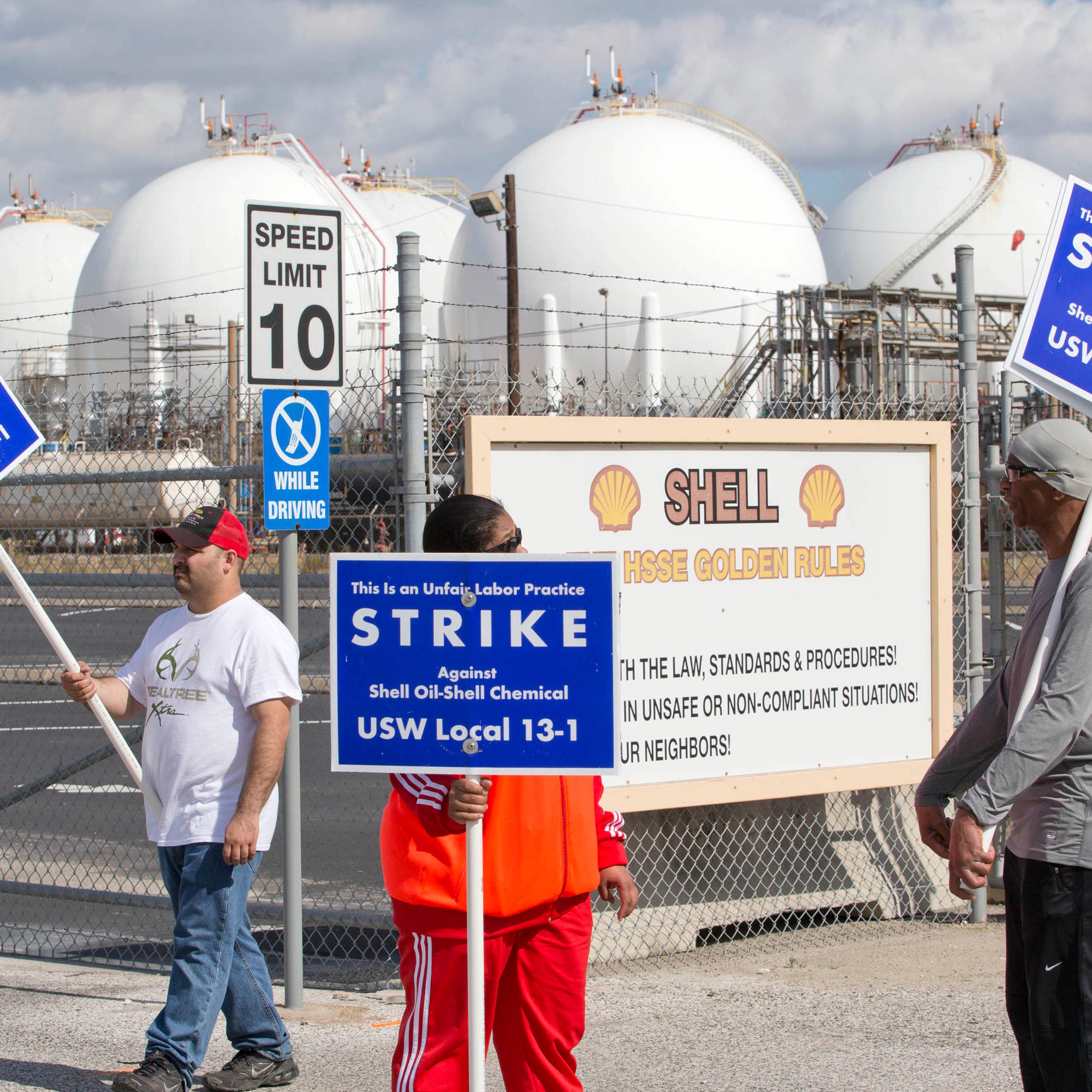 Workers from the USW union walk a picket line outside the Shell Oil Deer Park Refinery in Deer Park, Texas