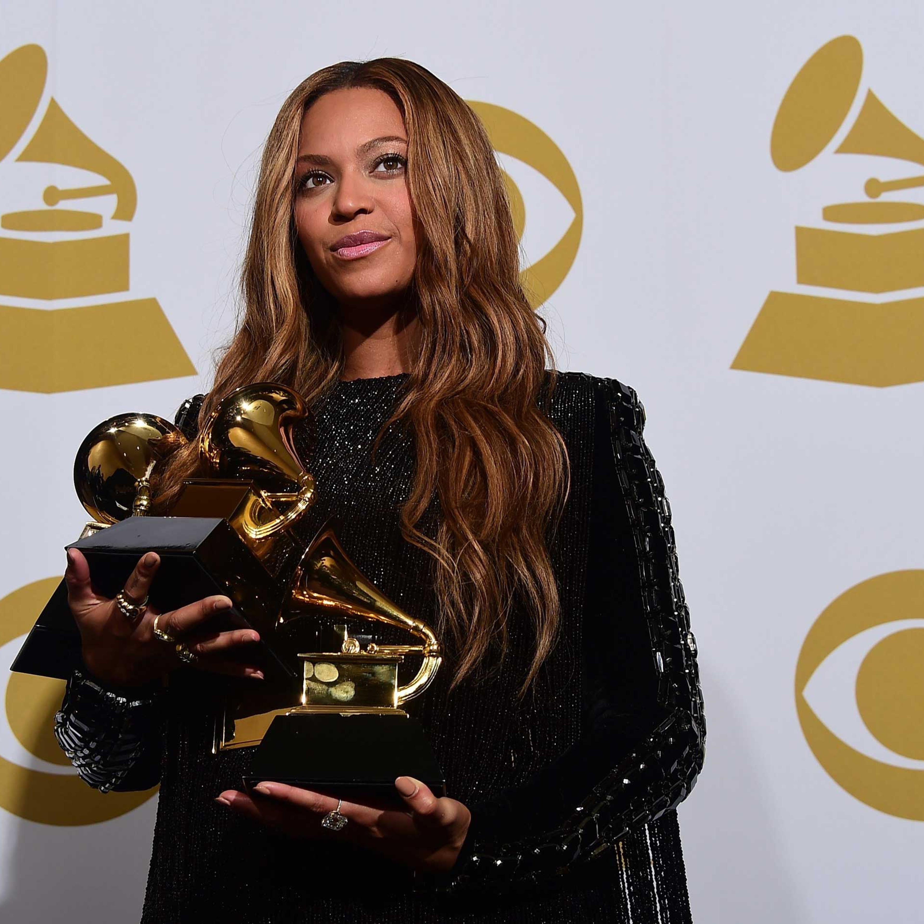 Beyonce poses with her three Grammys in the press room during the 57th annual Grammy Awards in Los Angeles, Feb. 8, 2015.