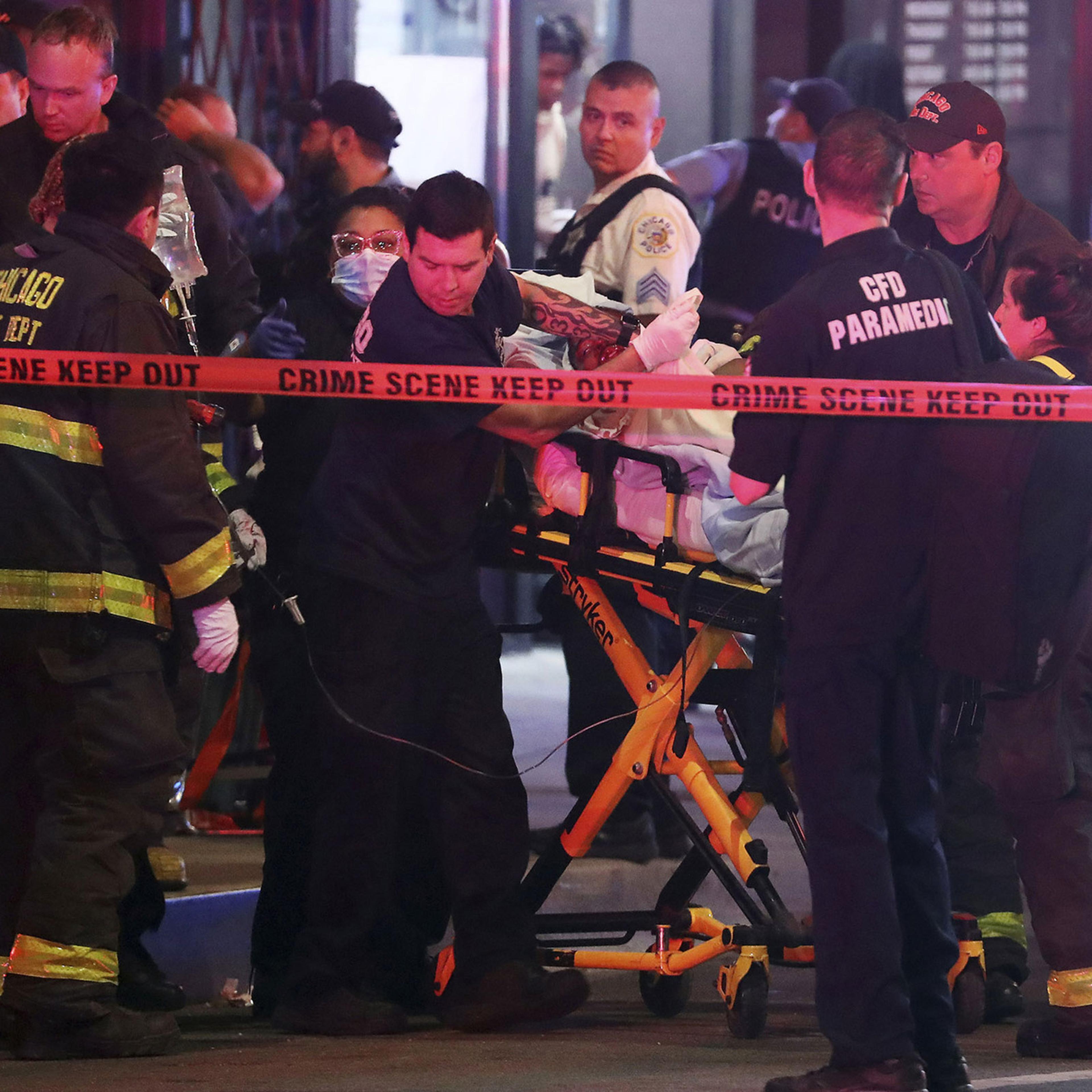 First responders move a shooting victim to an ambulance in downtown Chicago, May 14, 2022. A teenage boy was shot and killed near the sculpture Cloud Gate in Millennium Park.